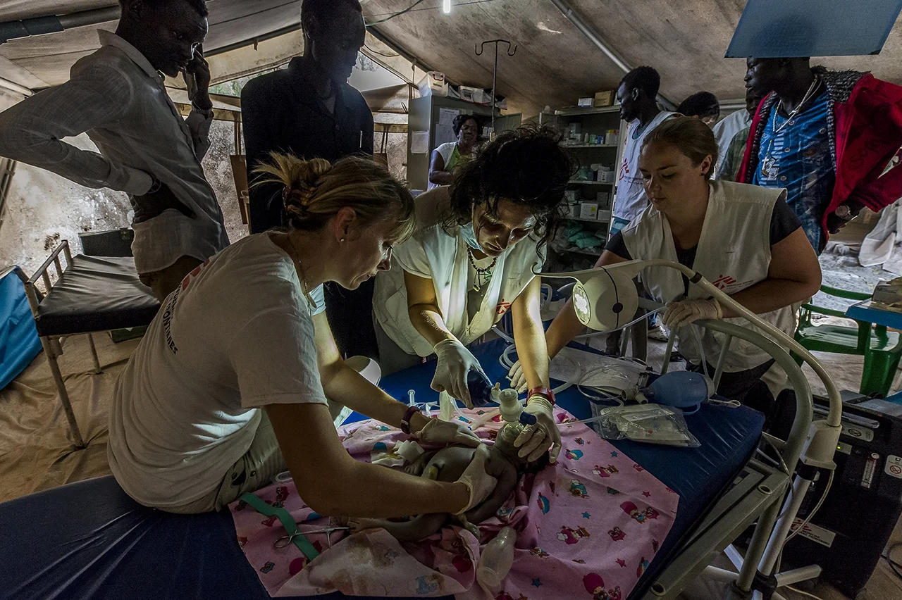In the emergency ward of the MSF clinic in Old Fangak, a large tent, Camille, the midwife, assisted by two nurses, tries to resuscitate a newborn, just out of the womb, taken in emergency. The newborn will not survive.