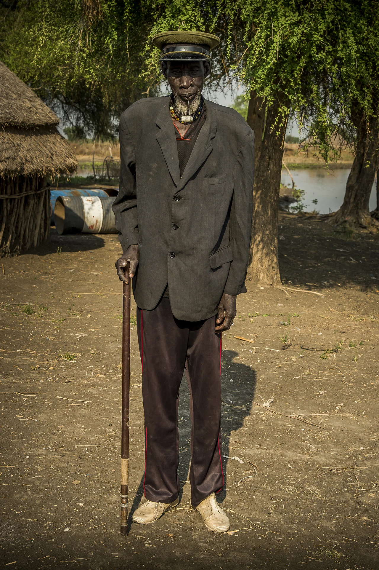 Riek Duor, more than 80 years old as far as he remembers, posing along the banks of Pibor river, somewhere in Upper Nile State, in opposition stronghold, South Sudan. A man proud of his cap which he wears since he was in the Sudan army, a long time