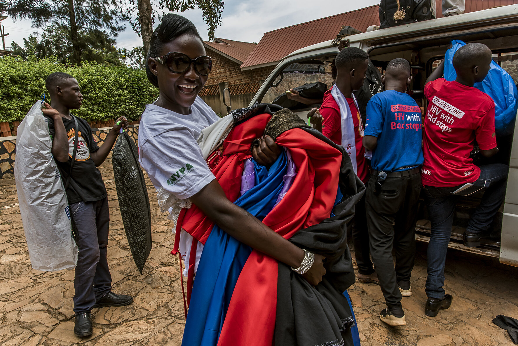 The sixteen candidates load their outfits into a mini van designed for fourteen people who will transport them to the Sheraton hotel, the grand hotel in the center of Kampala where the competition is organized. Dresses, tuxedos and shoes will be stu