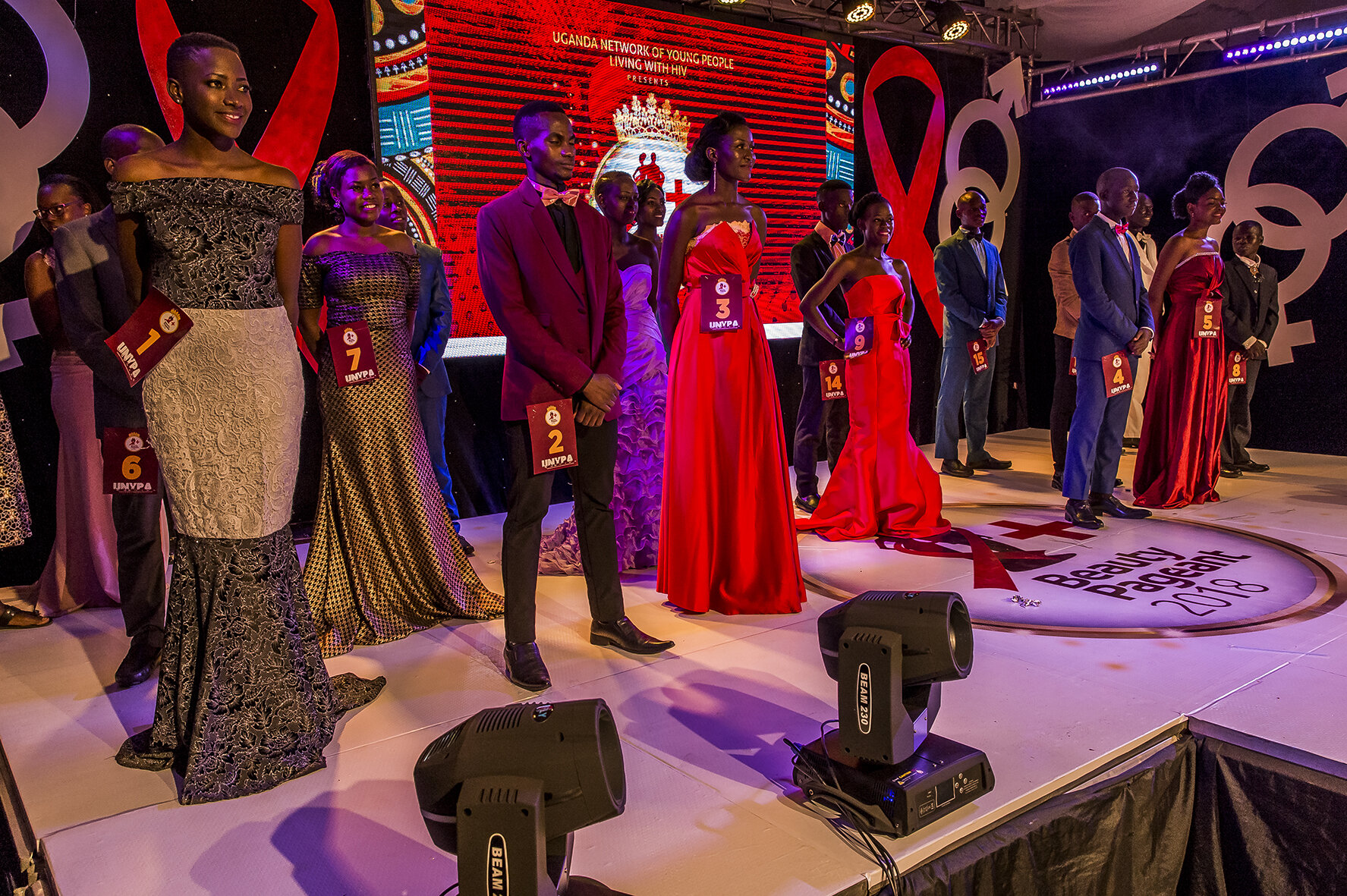 After several appearances on the stage in several outfits, the candidates standing in the back of the stage are waiting for the finalists' names to be called.
