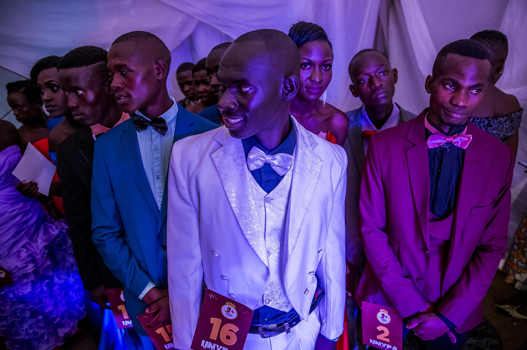 Candidates watch from behind the scenes as their colleague parade, ready to appear at the signal of a stage manager.