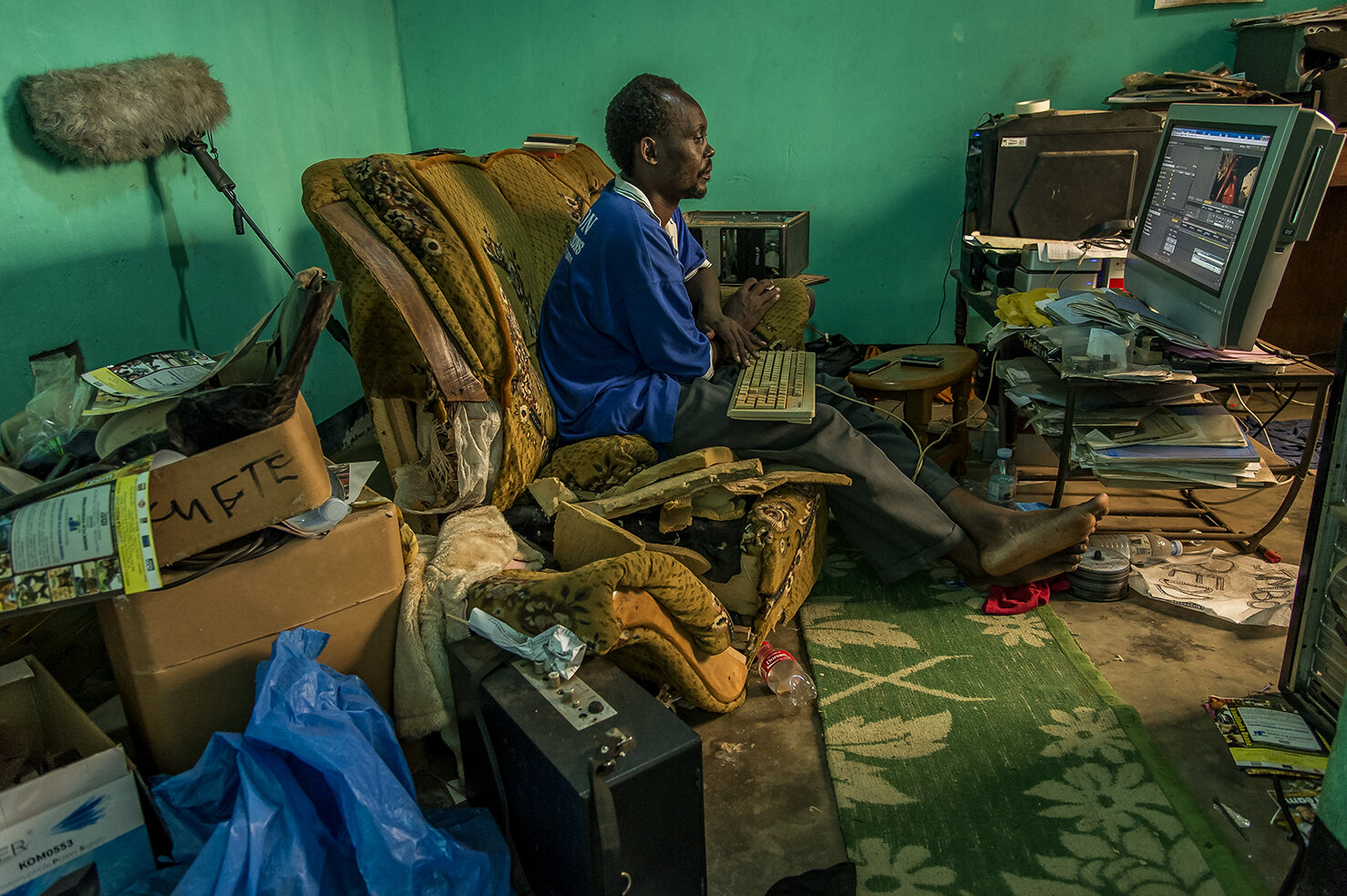  The first editing studio of Isaac Nabwana, a room in his house in Wakaliga area. His editing computer was the vertical black one set on a desk. The screen, the white dusty one in the middle. By lack of means, ICG did not have external hard drives to