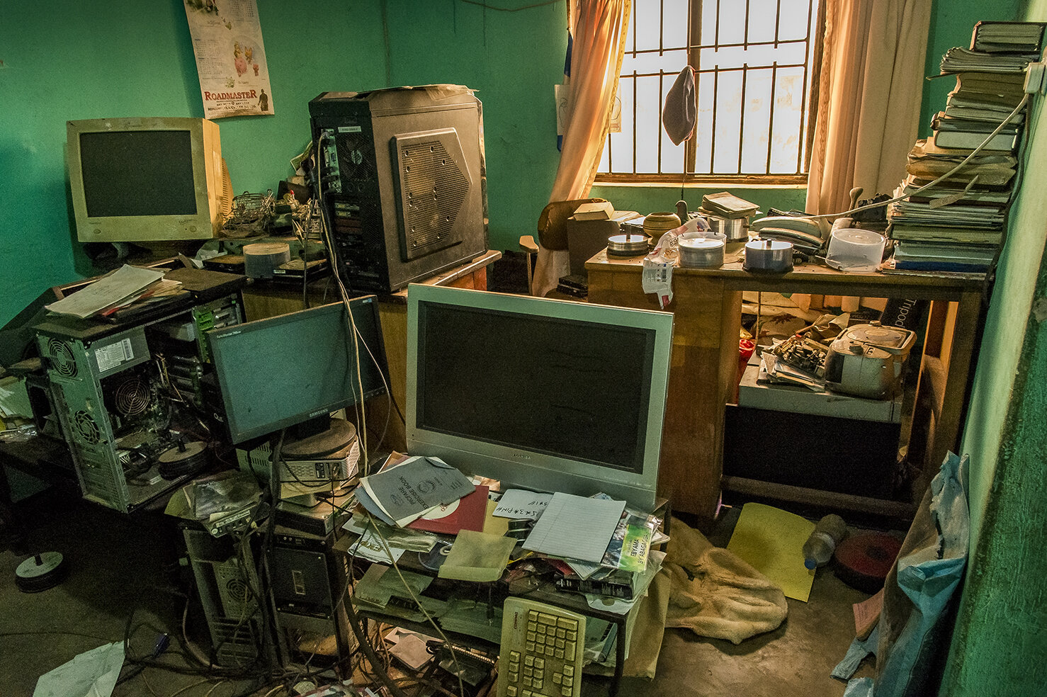  The first editing studio of Isaac Nabwana, a room in his house in Wakaliga area. His editing computer was the vertical black one set on a desk. The screen, the white dusty one in the middle. By lack of means, ICG did not have external hard drives to