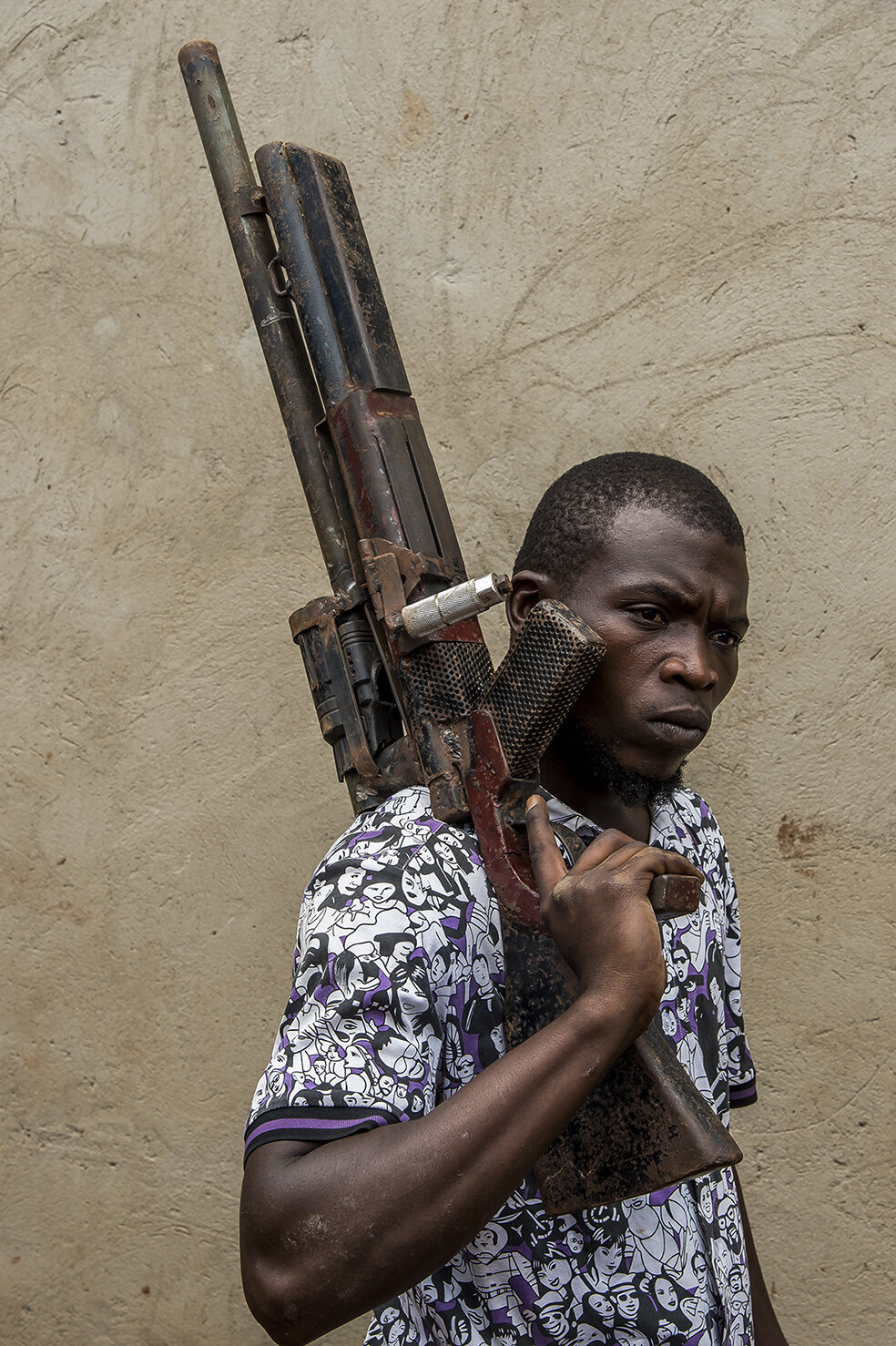  Appollo ASIIMWE, stuntman and actor of Ramon Studio strikes the pose with a machine gun made by Daouda Bisaso, the prop-man. 