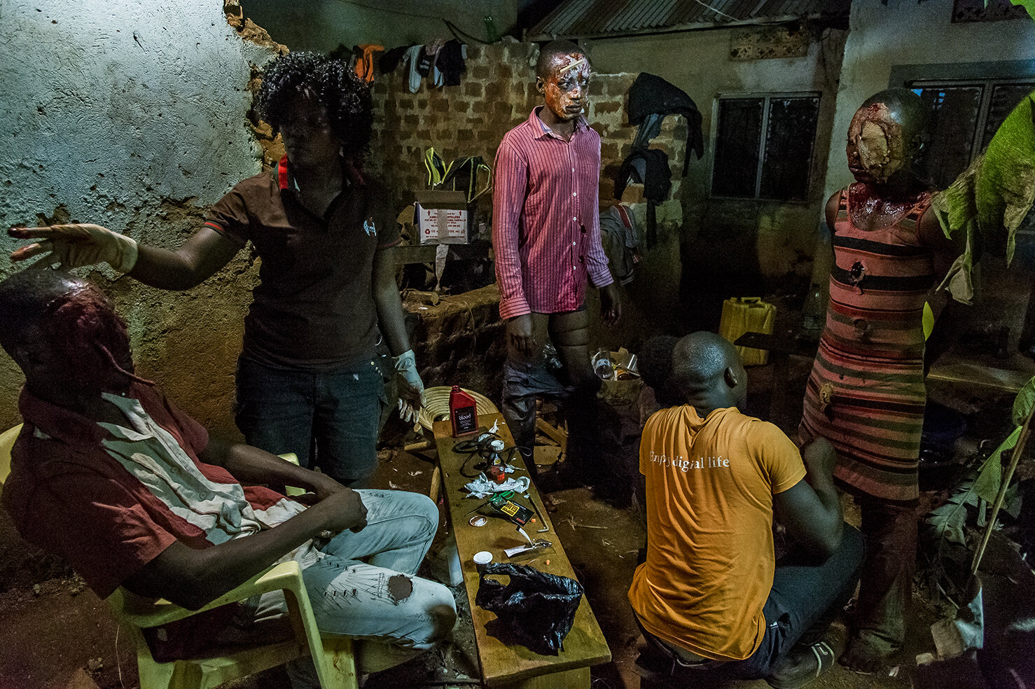  Gitti Nakasujja, the wife of Isaac Nabwana makes up the faces of the actors who are playing the part of the zombies / cannibals in the night sequence of «&nbsp;Eaten Alive&nbsp;». To create an effect of falling and bleeding skin, she uses toilet pap