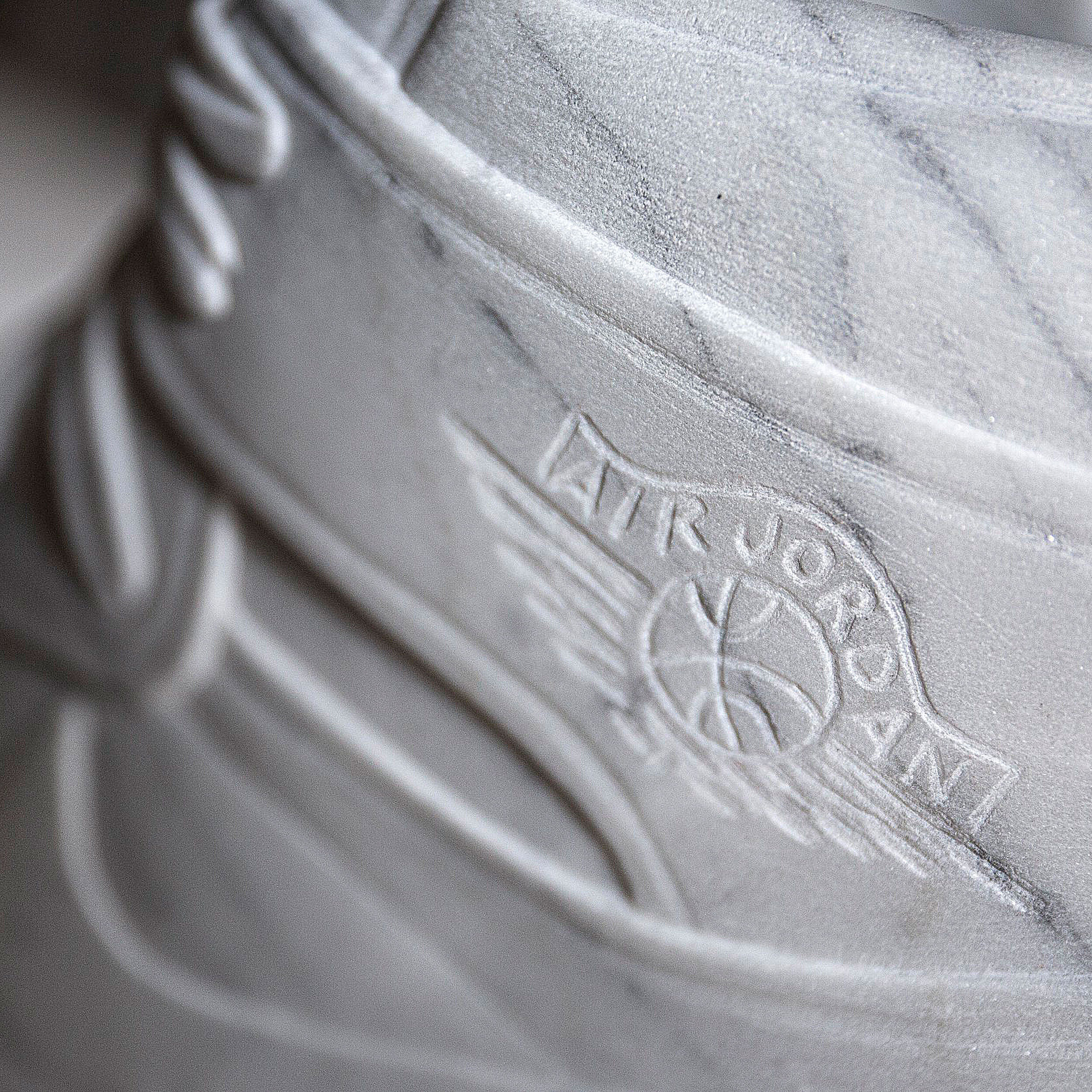 Hand inscribed marble shoe sculpted by Alasdair Thomson.
