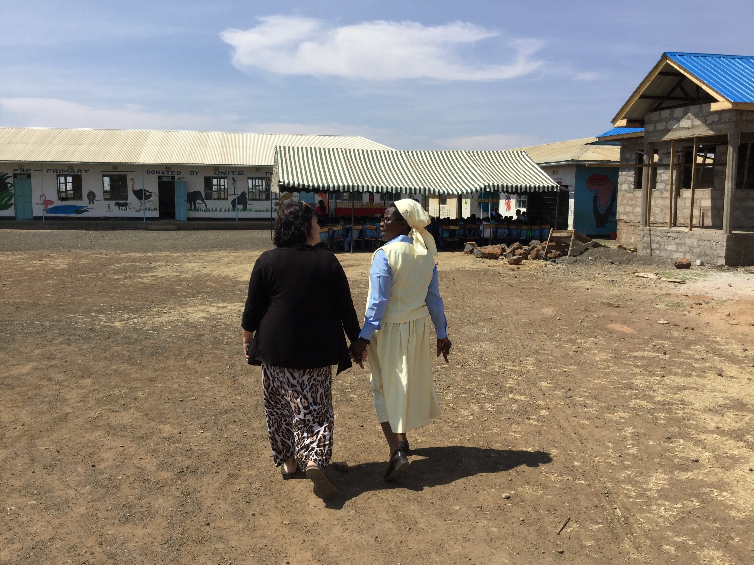Unite's program manager Deb Marshall and Sister Crispina Mnate, founder & director of St. Joseph's and Heaven stroll in front of the admin block while is was still under construction.