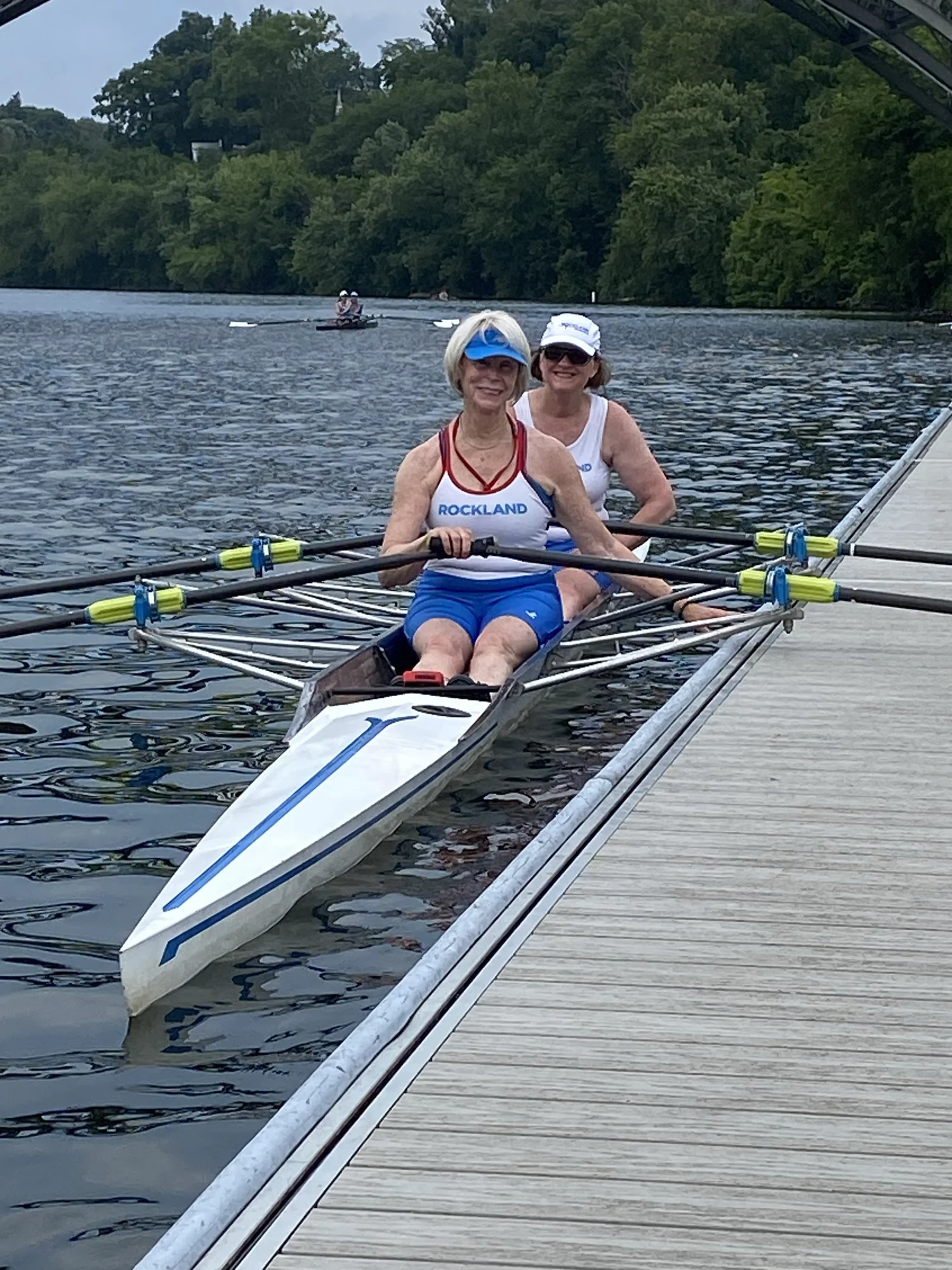 Two Rockland Rowing athletes in a double scull at the dock