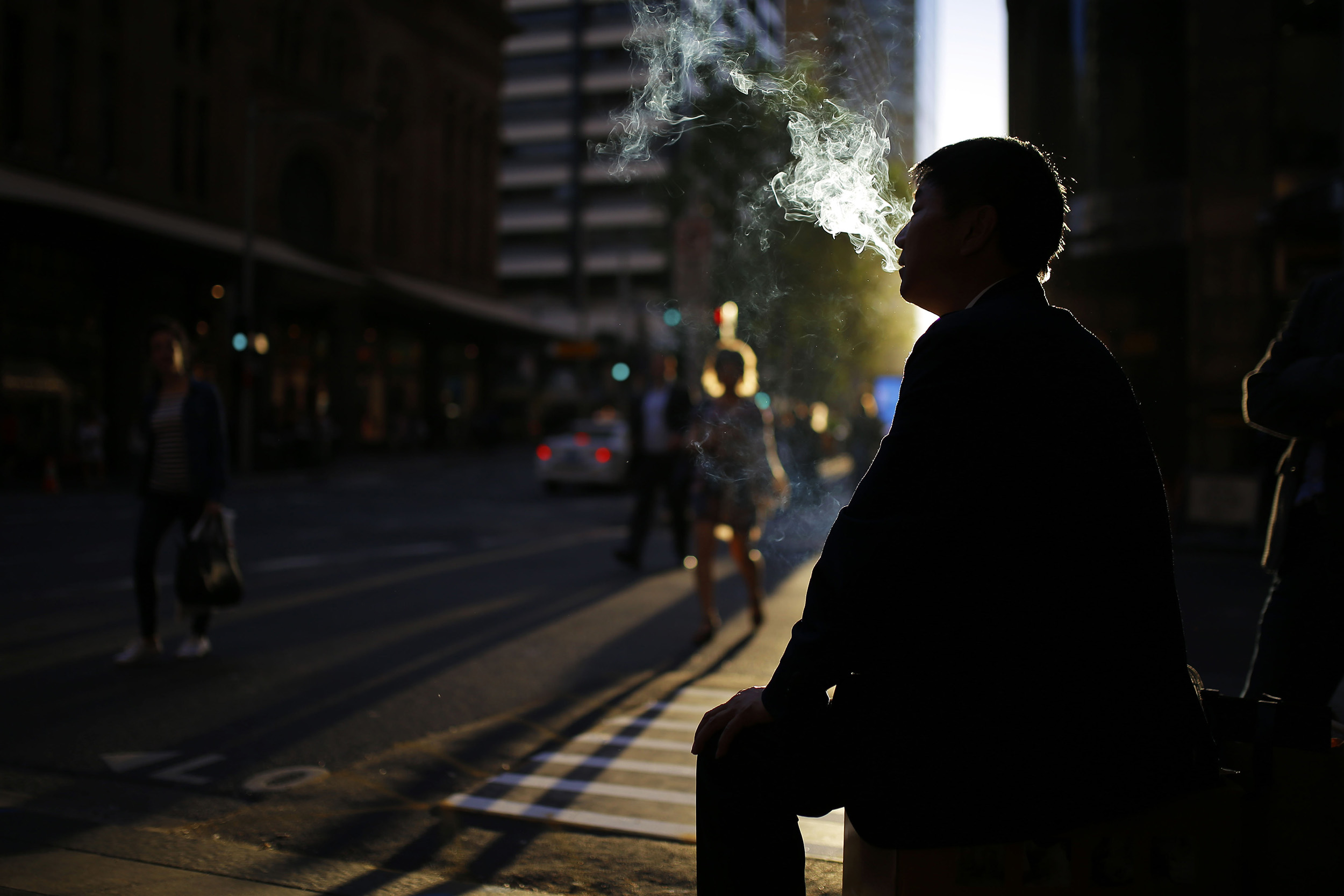  A man smokes a cigarette outside of an office building in central Sydney, Australia, October 25, 2016. 