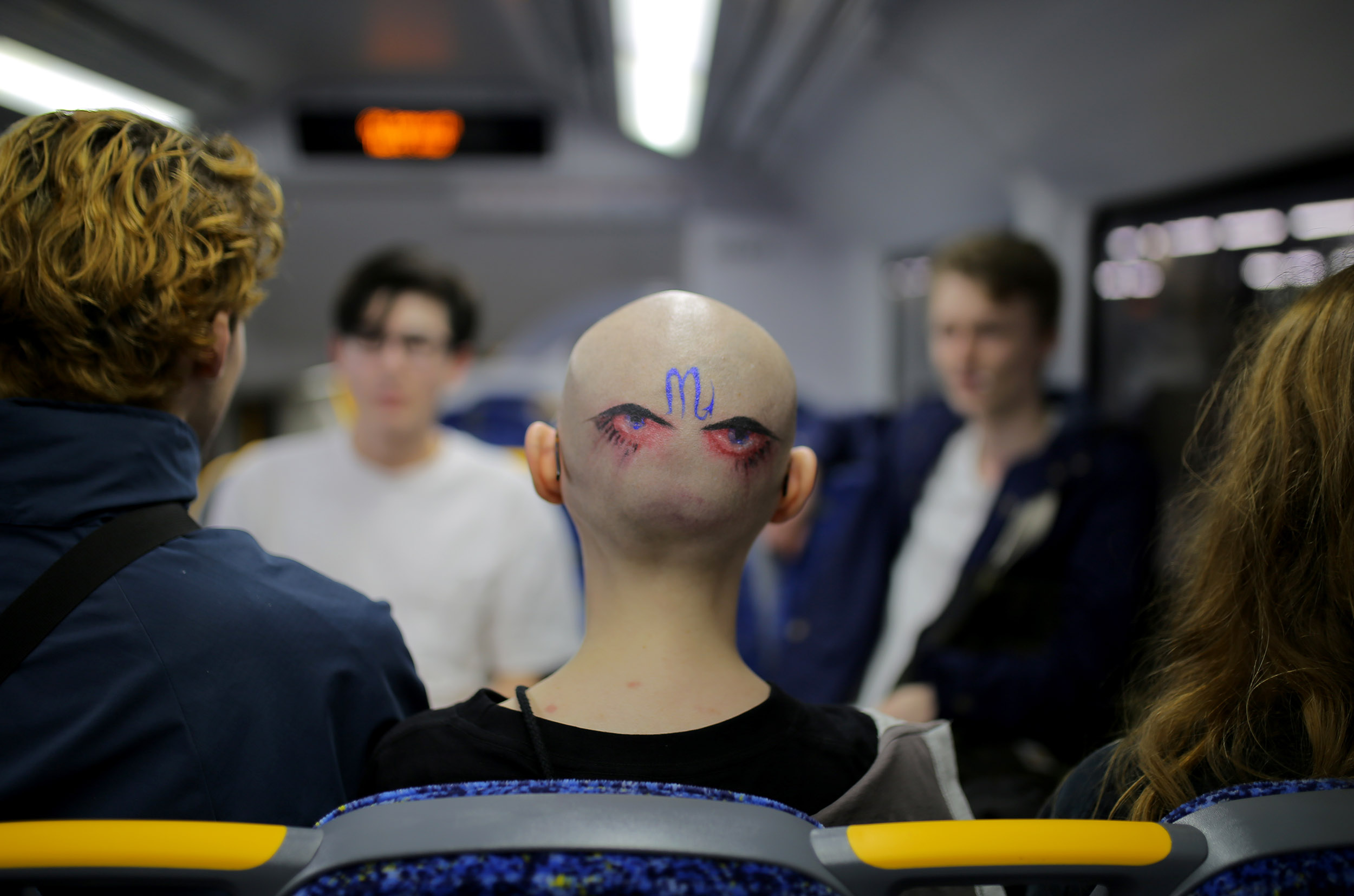  A girl with a pair of eyes and the Virgo zodiac symbol painted on the back of her head is seen on a train in North Sydney, Australia, March 20, 2017. 