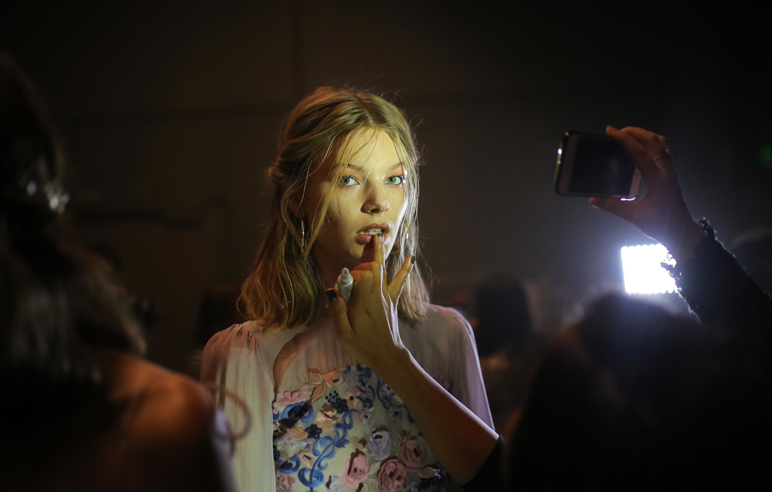  A model for We Are Kindred has makeup applied by mobile phone light back stage during Fashion Week Australia in Sydney, Australia. 