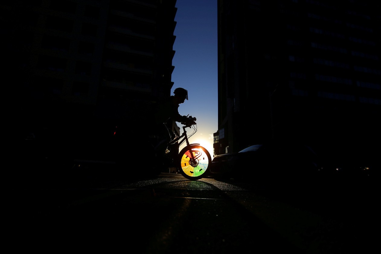  A cyclist rides into a shaft of light between two buildings in Sydney's business district, Australia. 