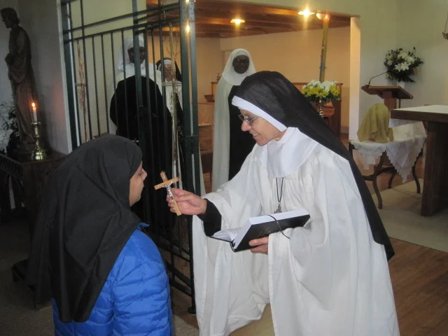 Rev.Mother Rachel (Prioress) gives a crucifix to Sr Theodora and says "Hearken O daughter, to the call of Christ as you take up your cross to follow him for he says - 'If anyone will come after me, let him deny himself, take up his cross daily , and follow me.'"