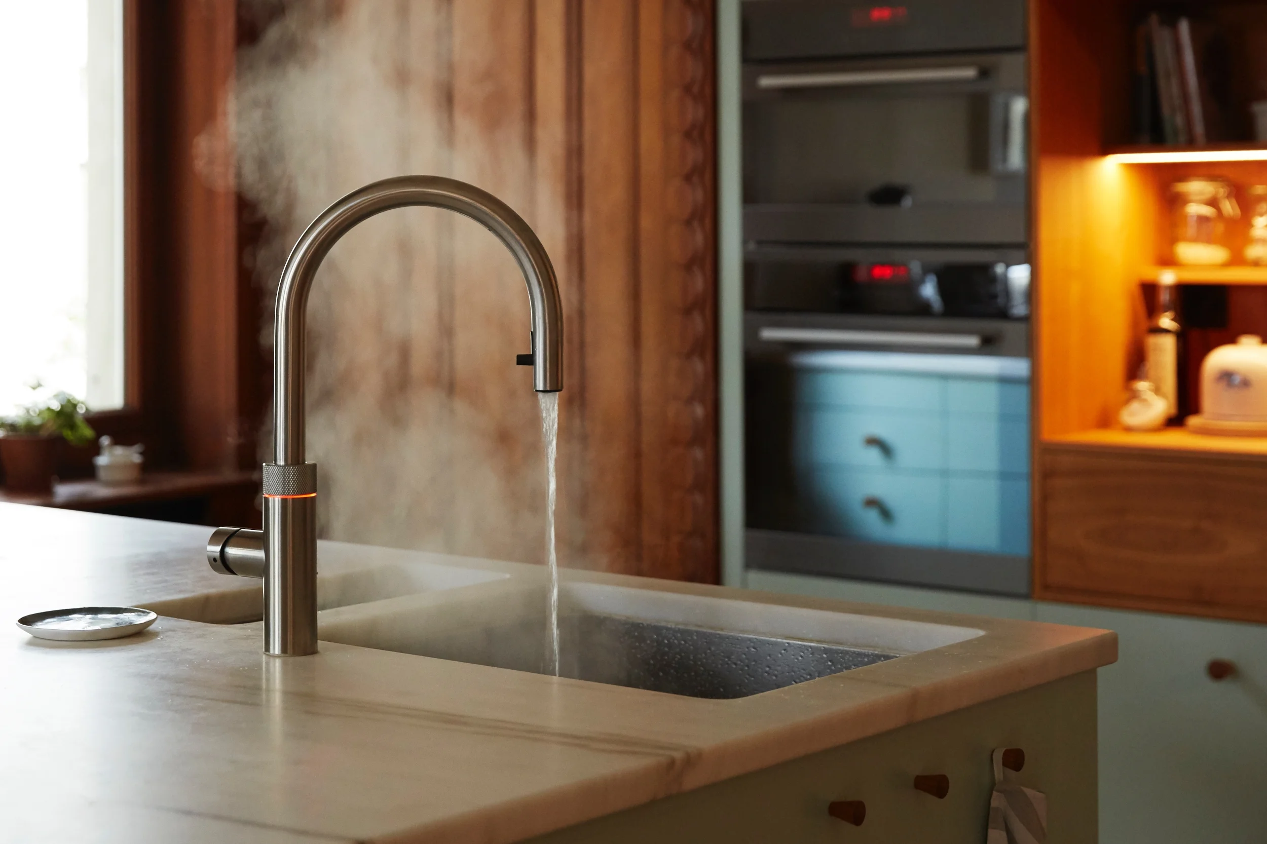 Die Ausstattung dieser schlicht wirkenden Küche lässt keine Wünsche mehr offen: Sie bietet eine Mischbatterie mit Kochwasser-Aufbereitung, einen Steamer, eine Backofen-Mikrowellenkombi, ein “knock to open”-Geschirrspüler und ein grosszügiges Gaskochfeld mit versenkbarem Dunstabzug. Zudem eine Brotschublade, einen grossen Kühlschrank und unzählige Auszüge, die alle mit modernster Küchentechnik ausgestattet sind.