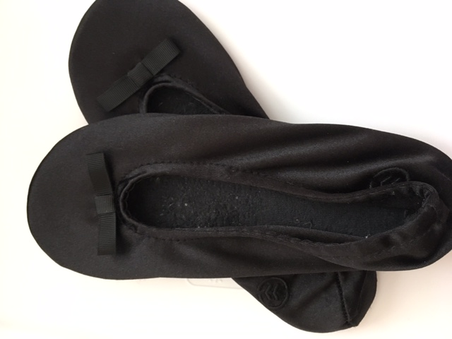 Isotoner brand ballet flat slippers slide into a carry on, have a good sole, and are machine washable.