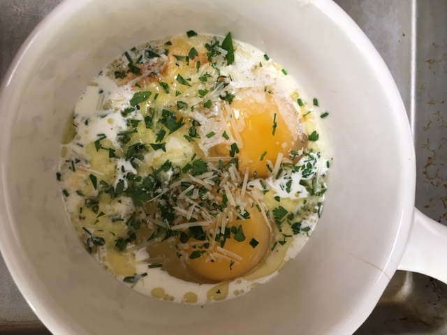Here the eggs are added to the bubbly cream and butter mixture, sprinkled with the herbs and cheese, and are ready for the broiler.