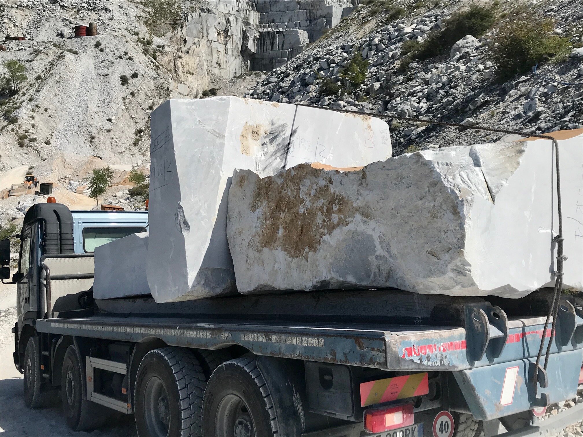 Tons of marble are carried down the mountain by truck