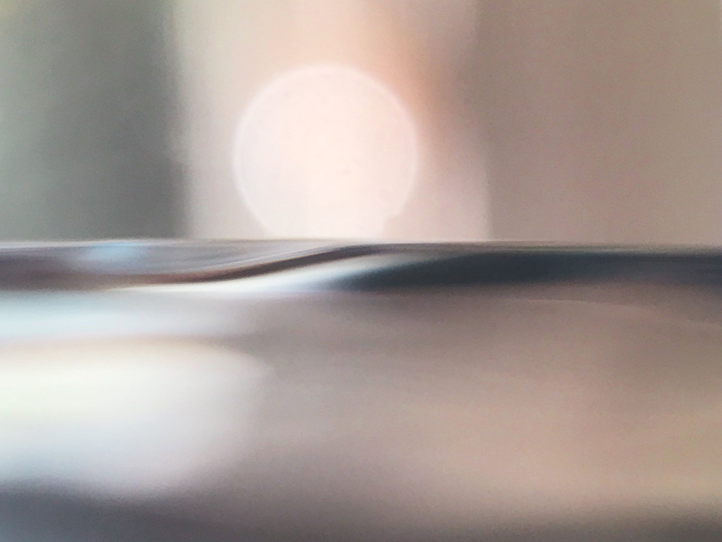Iphone 7+ - Sunrise? Sunset? Actually, this is my kitchen faucet in my kitchen sink, shot in macro, and turned 90 degrees counter clockwise. The "water" is the running faucet and the "sun" is bokeh, probably reflecting from gross food on a dish waiting to be washed.