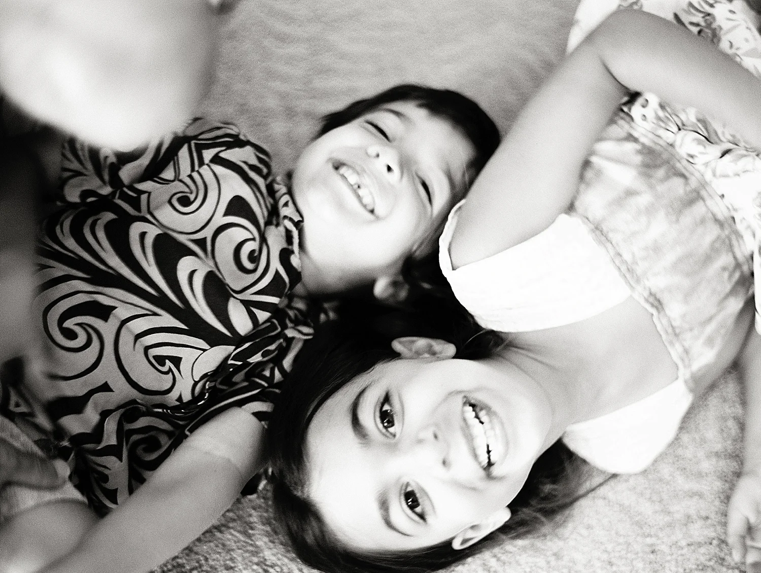 maui-black-and-white-photography-siblings-on-floor-laughing-together