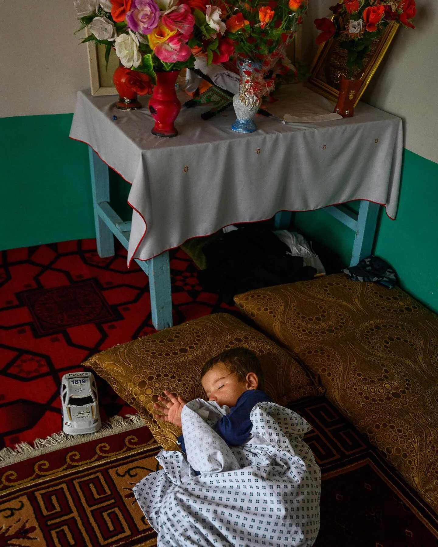 Zaifa, 4, lost his father in a US airstrike in 2019 when on his way home in a car. Six other relatives were killed. Here, Zaifa sleeps in the home where he lives with his mother and grand-mother, under a table where they put plastic flowers his fathe