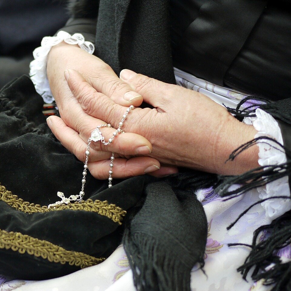 Woman Holding Rosary in Prayer