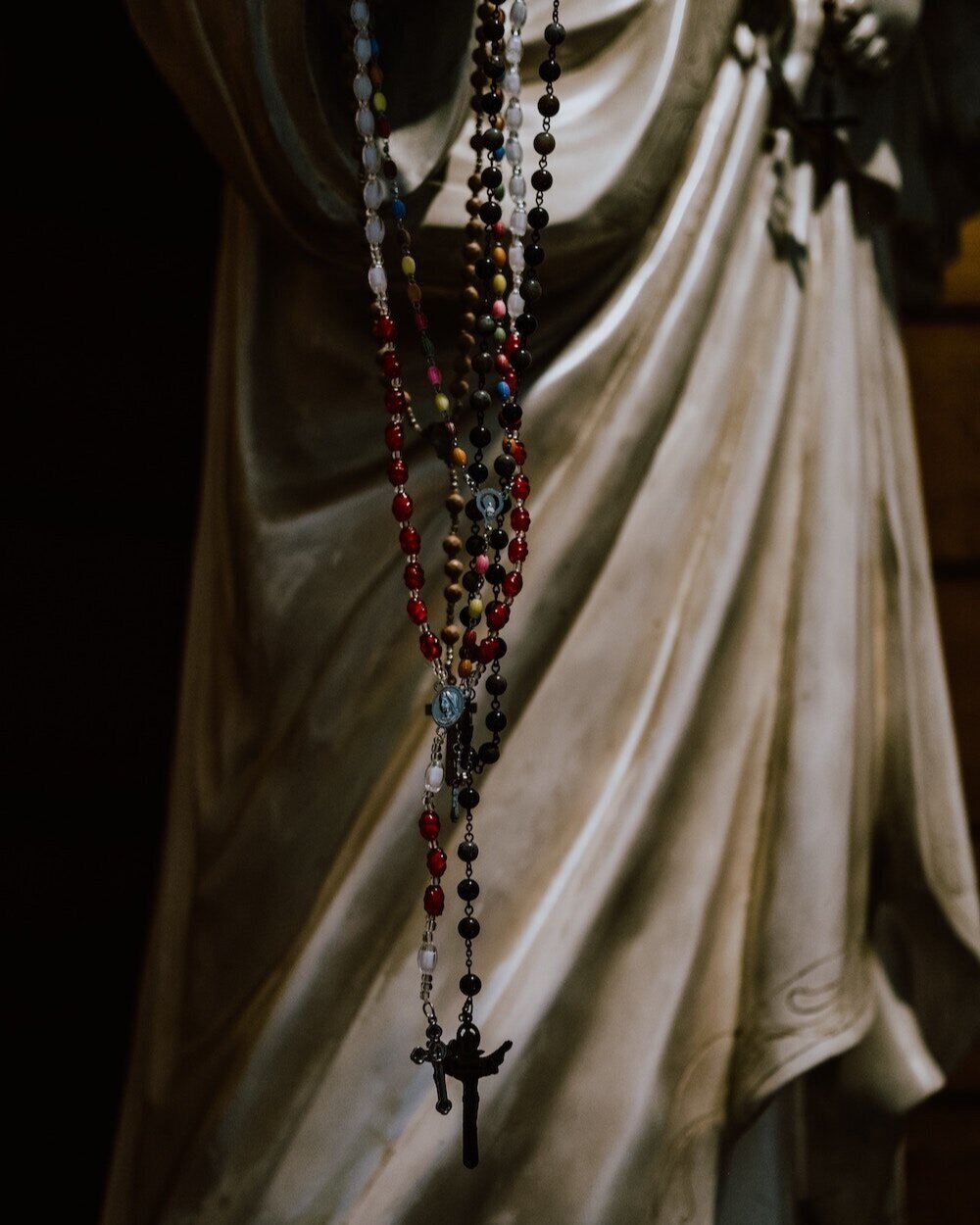 Rosaries Hanging on Statue