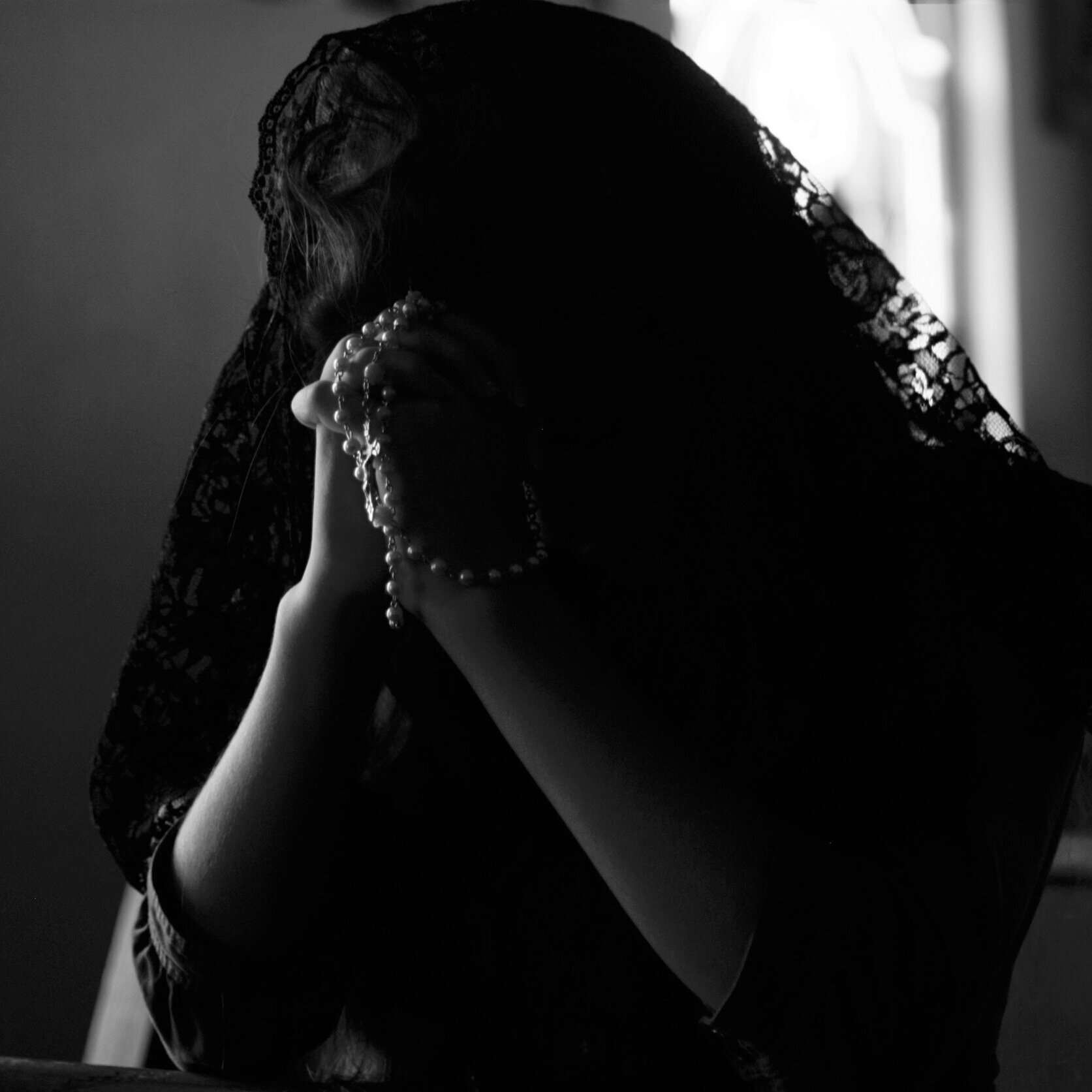 Woman Praying the Rosary in Church