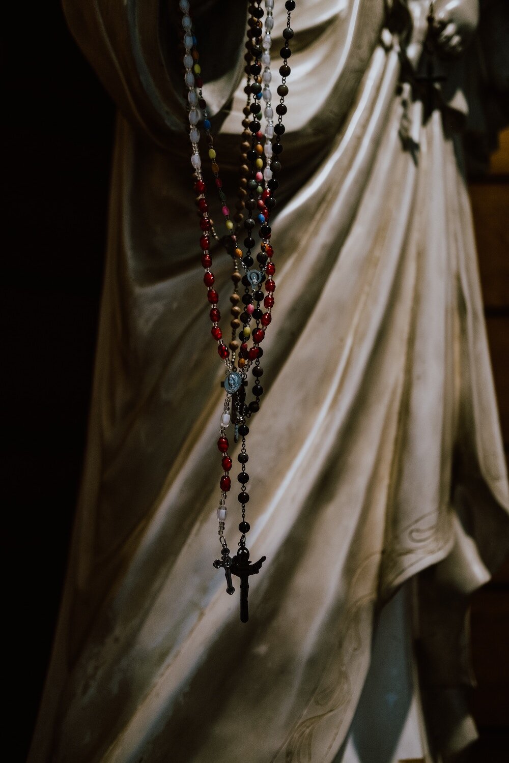 Rosaries hanging from Statue