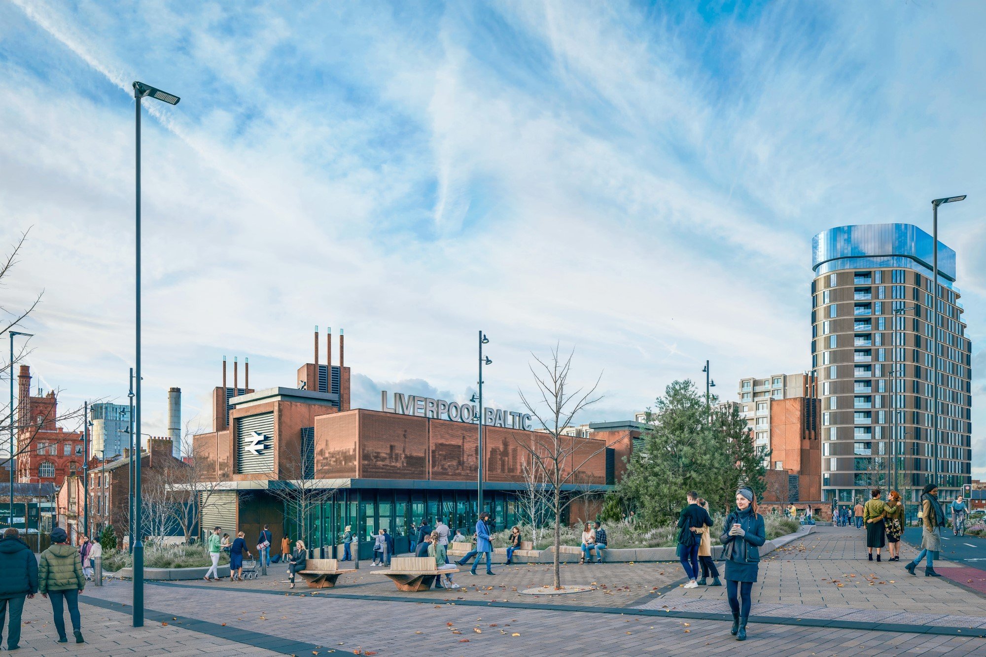 Busy exterior of a red brick large train station. Modern glass lower level and benches in a courtyard outside. Lots of pedestrians coming and going.
