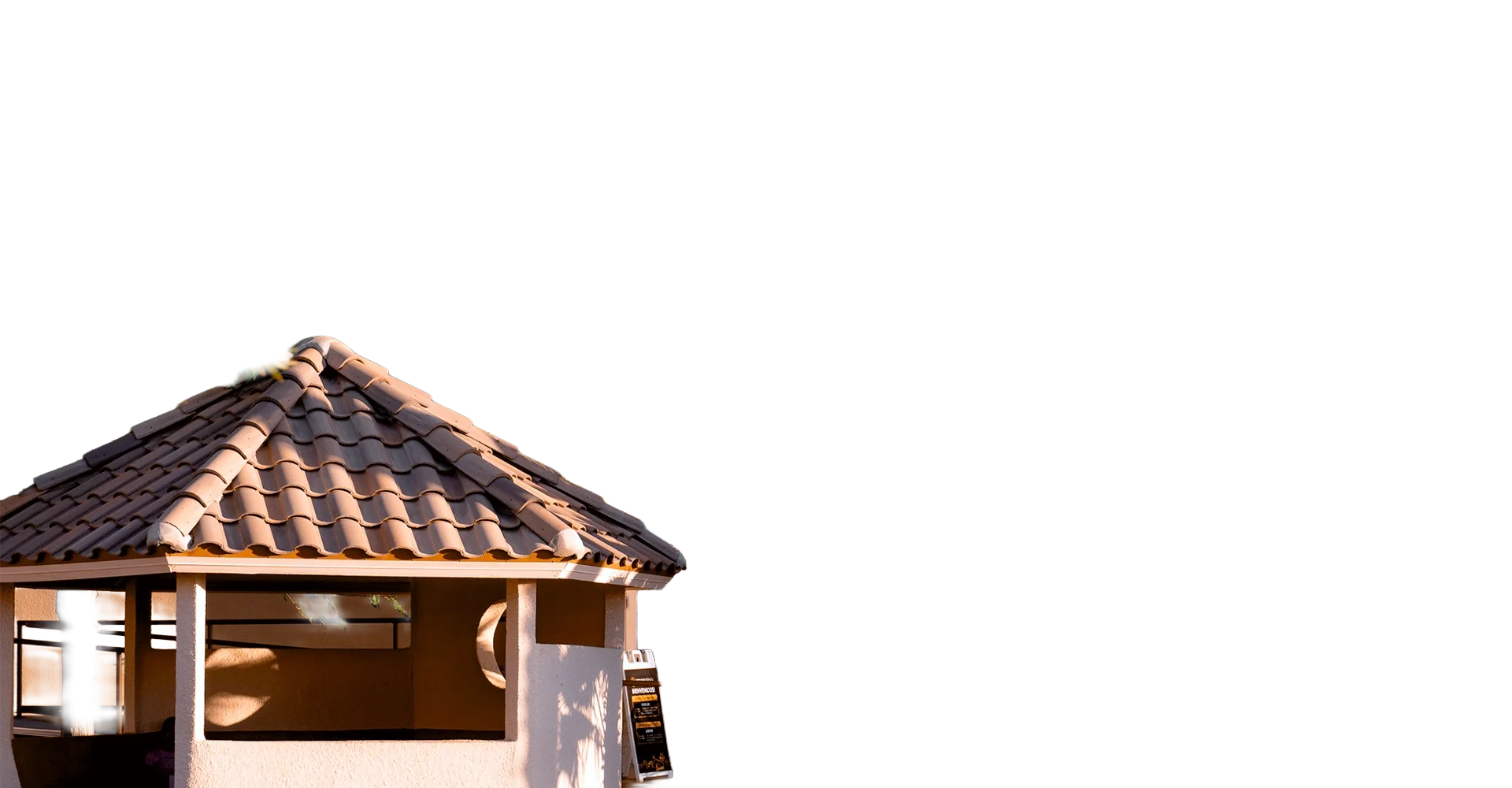 A small outdoor structure with a tiled, cone-shaped roof in an earthy tone, supported by white columns.