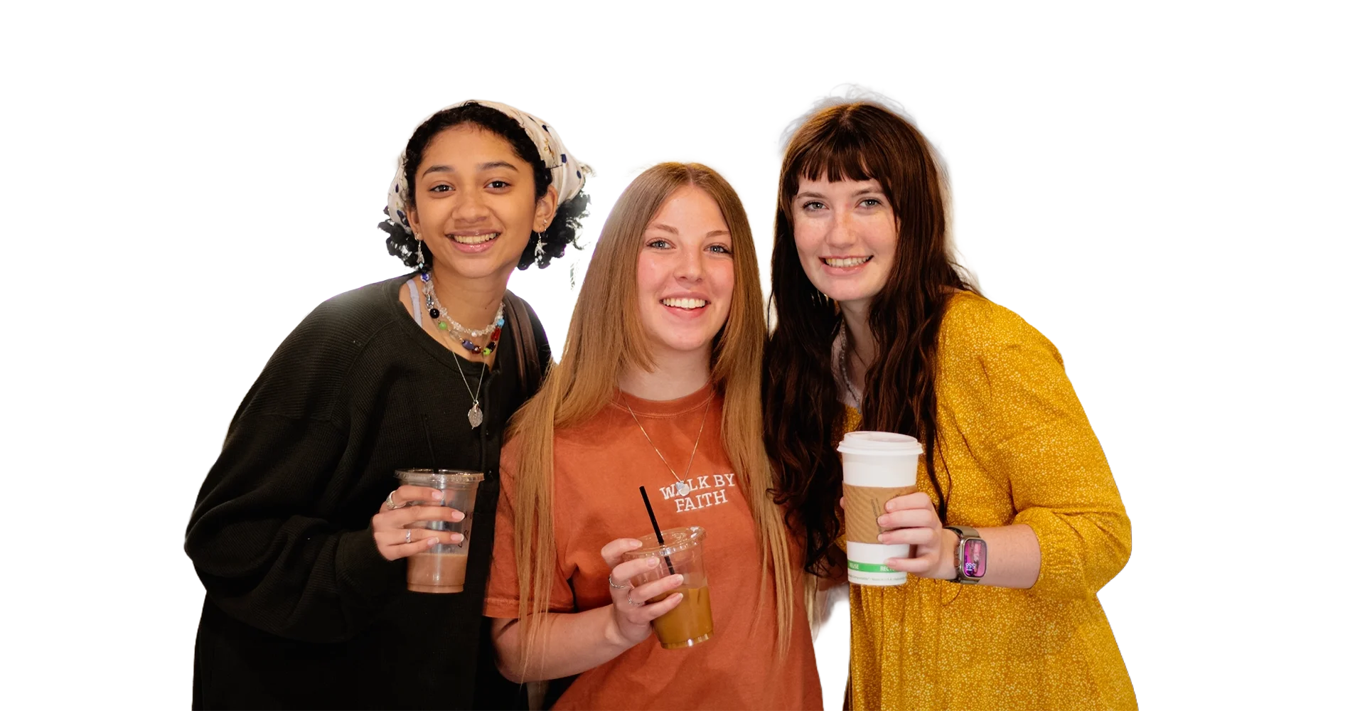 Three young women holding coffee cups and smiling.