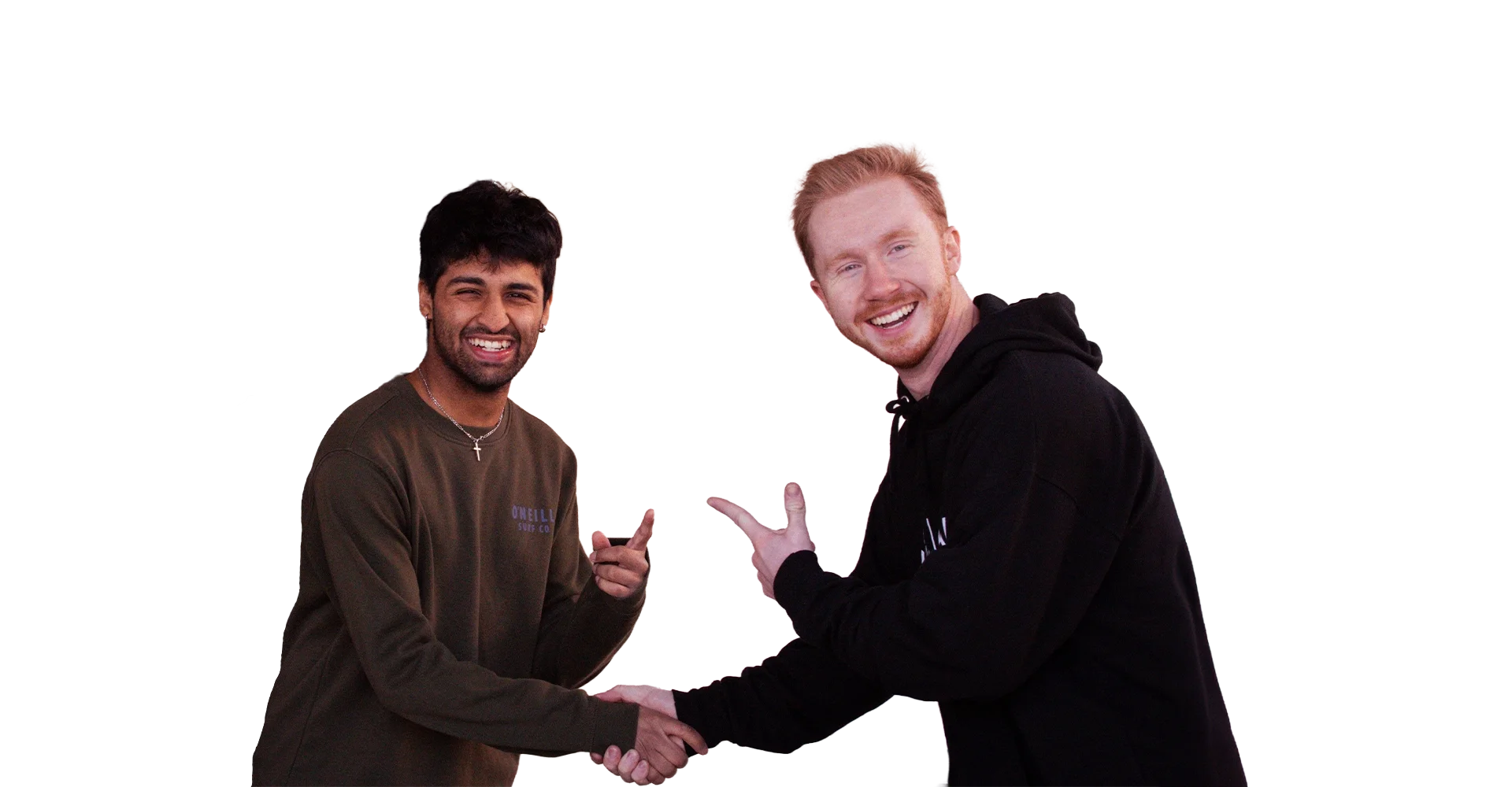 Two young men smiling and shaking hands, one with dark hair and wearing a brown sweatshirt, and the other with red hair wearing a black hoodie, standing against a blurred striped background.