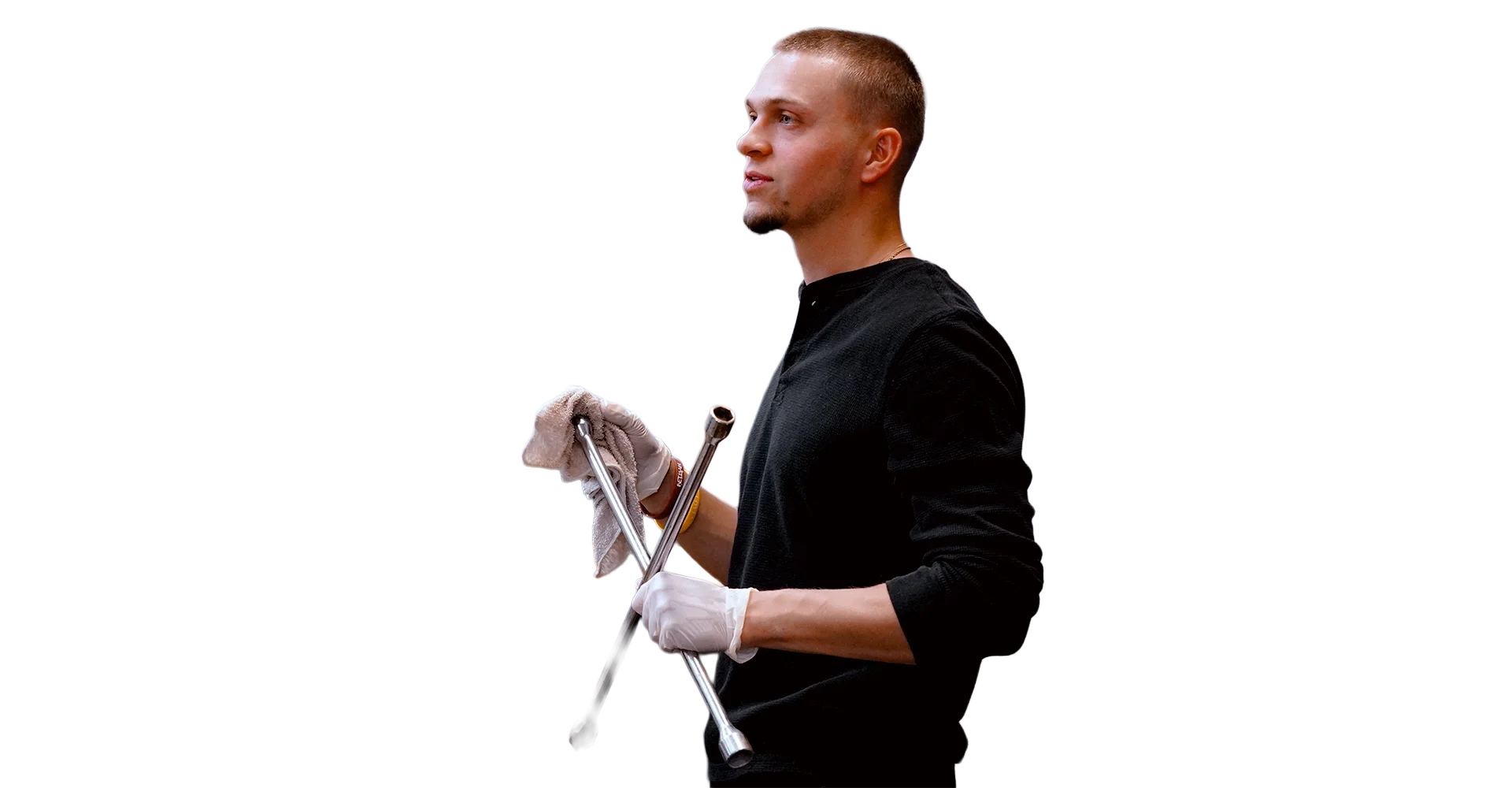 A young man with short hair and a goatee, wearing a black long-sleeve shirt, holding crutches with one hand and a towel in the other, standing against a plain background.