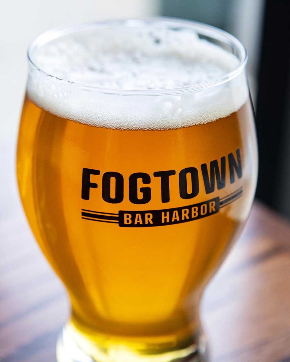 Beer in glass with Fogtown Bar Harbor logo.