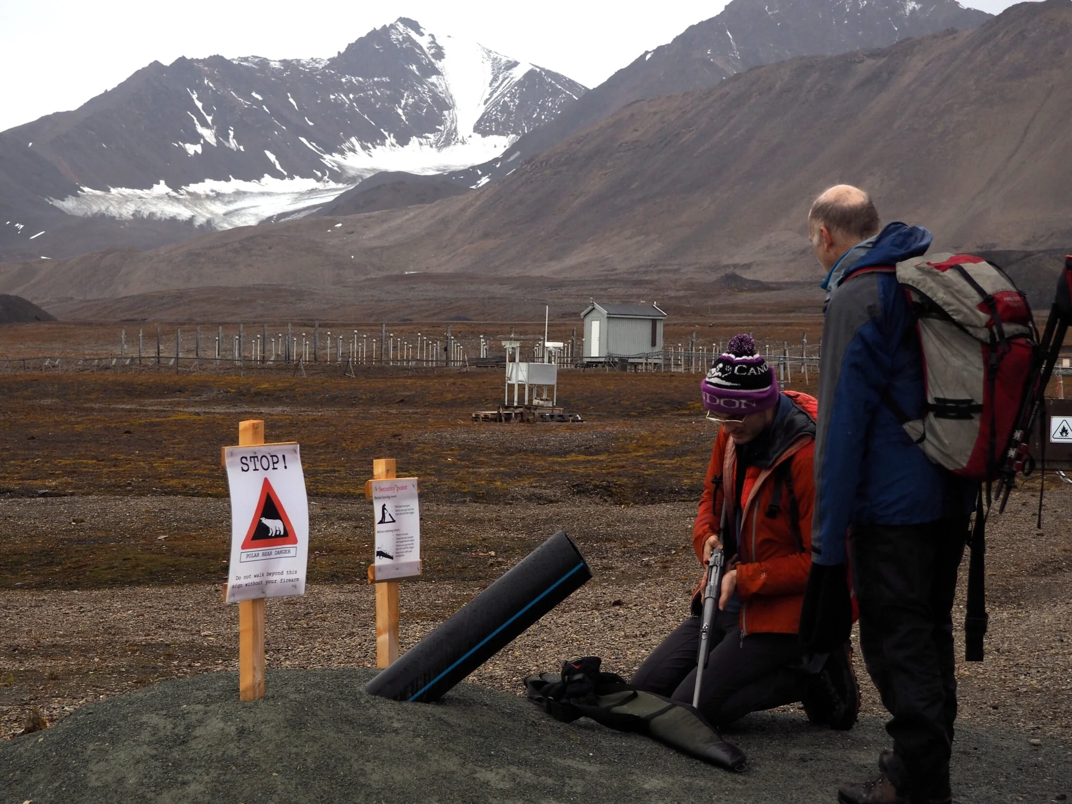 Robbie half-loading a rifle at the edge of the Ny-Ålesund safe zone. Photo: Aurelia Reichardt (BAS)