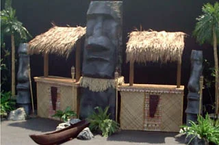 'TIKI BARS' The Basic Tiki Bar measures approx 16' wide x 10' high x 5' deep and does not include the large statue in the center. The Grand Tiki Bar measures approx 20' wide x 10' high x 5' deep and does includes large statue as seen in the photo. Either setup is ideal for anyone that wants the coolest tiki bar at their luau event. $650 — Basic Tiki Bar $900 — Grand Tiki Bar
