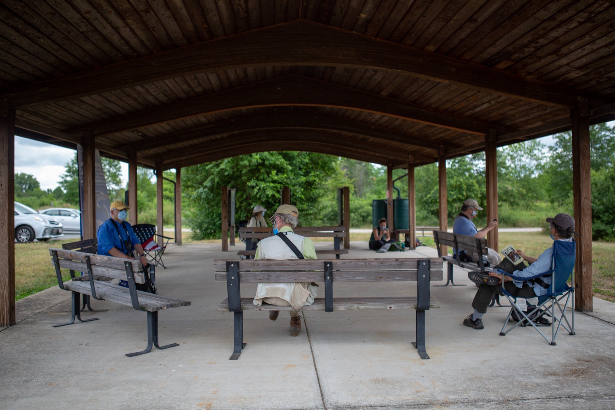  The citizen science group tallies data after a morning of counting butterflies and dragonflies. The group has put social distancing rules in place such as requiring masks and only allowing one person per bench. Many members even bring their own fold