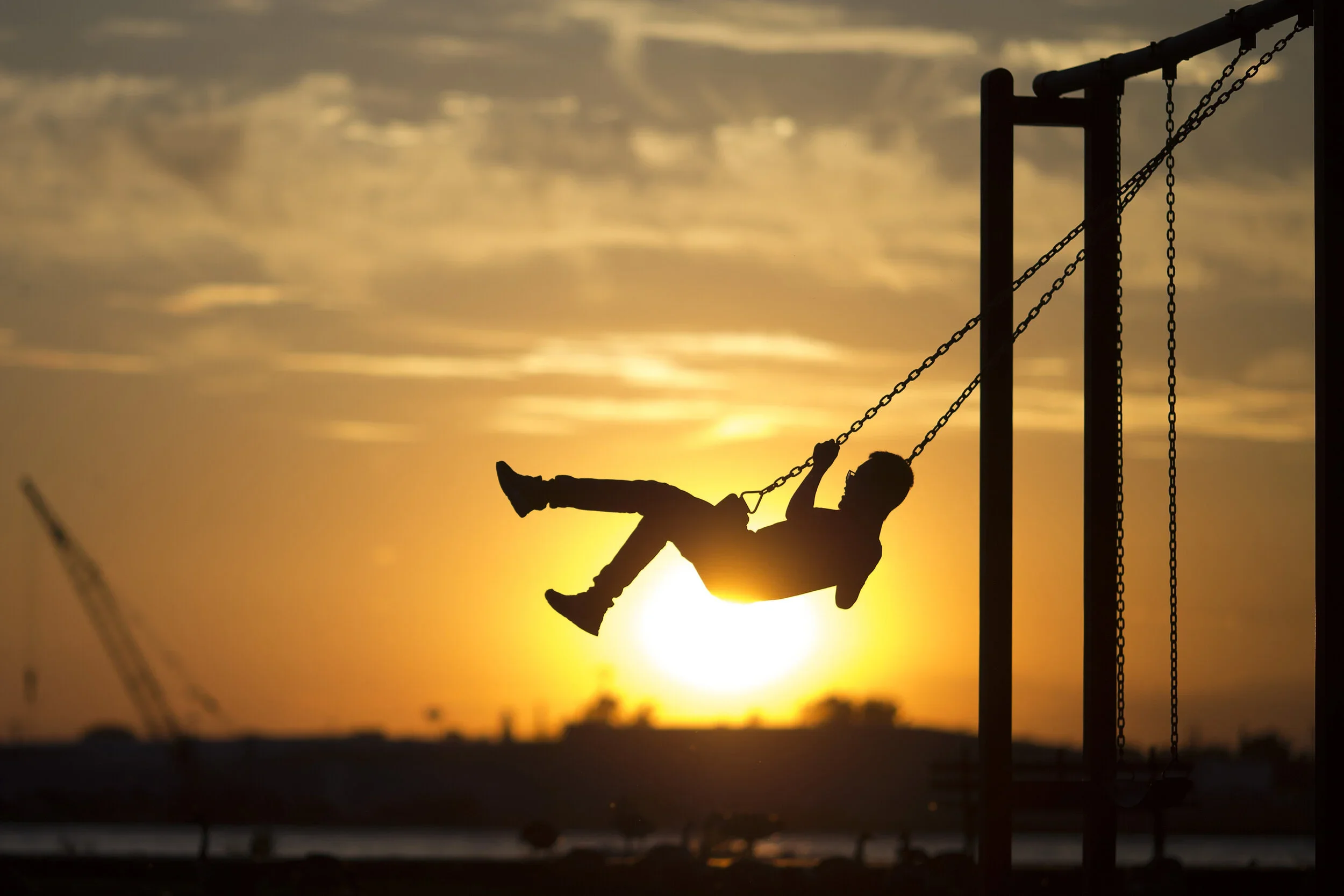  Li Xirui, 13, visiting from China, is pushed on the swing by his mother at McKee Park at sunset (for the Windsor Star, 2017). 