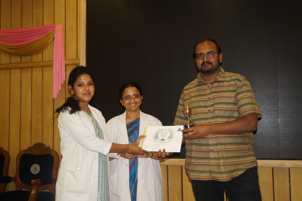 Dr.Nandhini getting the workaholic award from the Dean and the Director of Academics