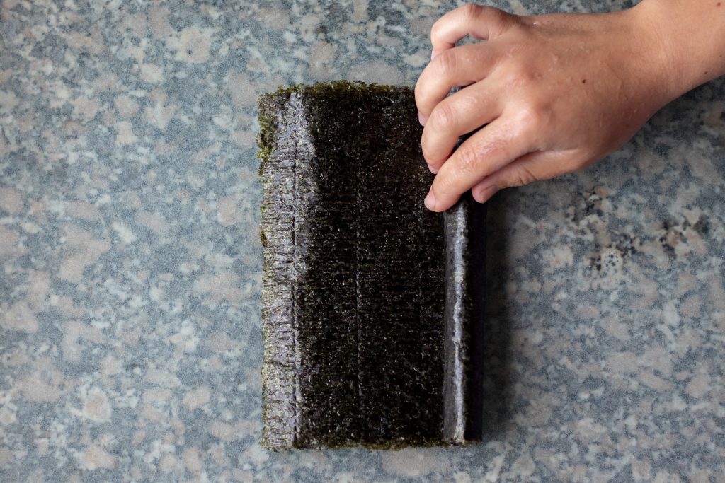 Toma la hoja de nori y enróllala en forma de tubo.