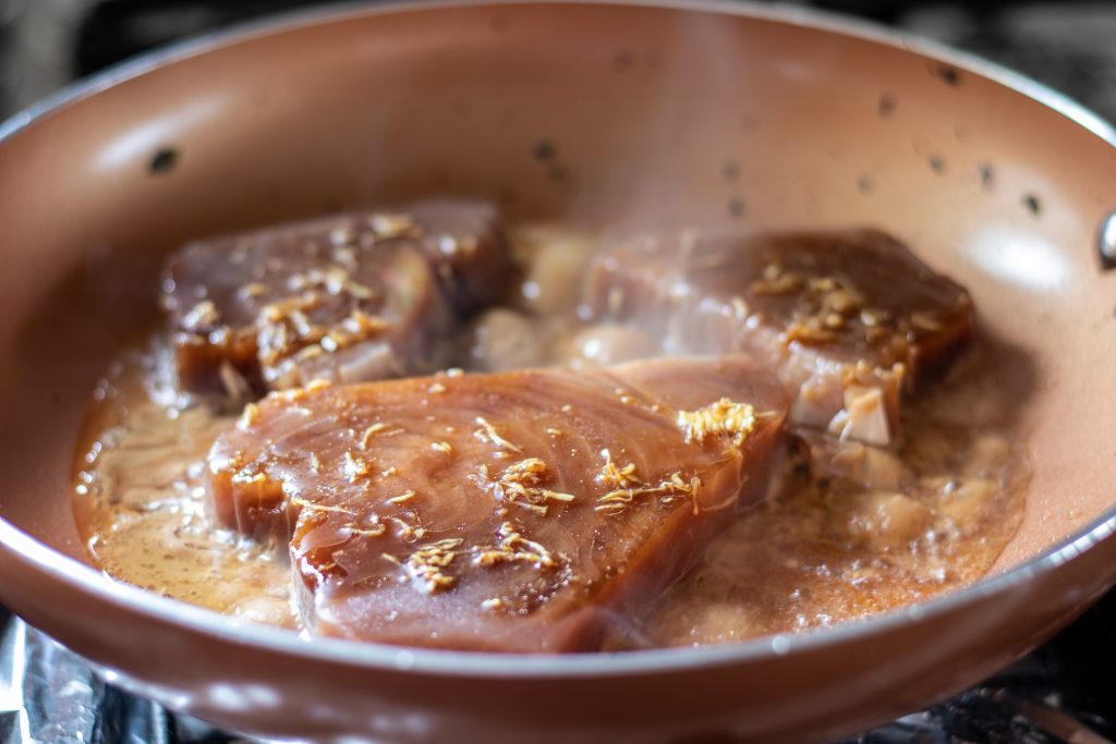 En el mismo sartén agregamos el aceite de sésamo y colocamos los filetes de atún, y dejamos que se cocinen de 10 a 15 minutos, hasta que queden dorados.