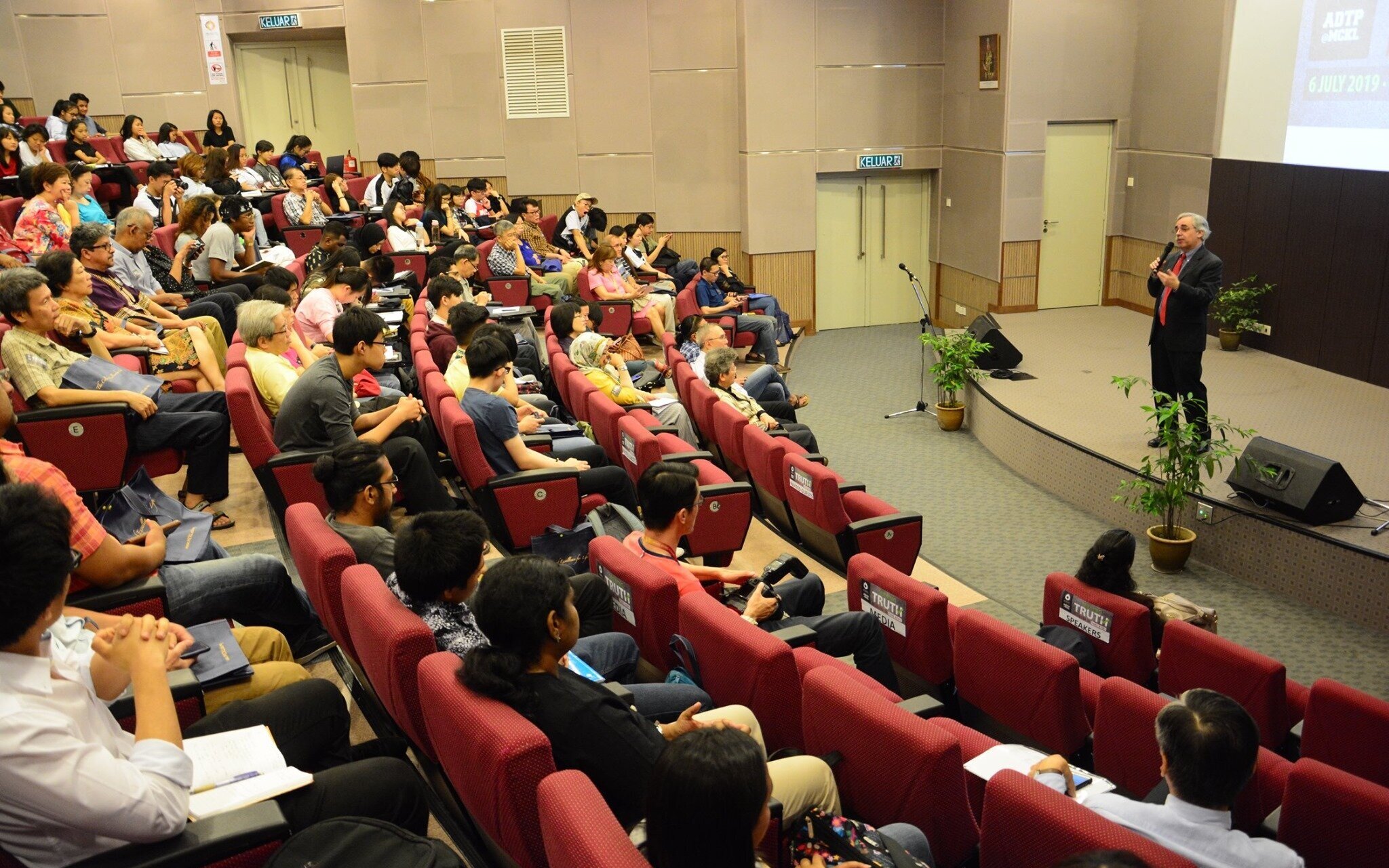 Image of a male Specialist standing on a stage speaking to an audience.