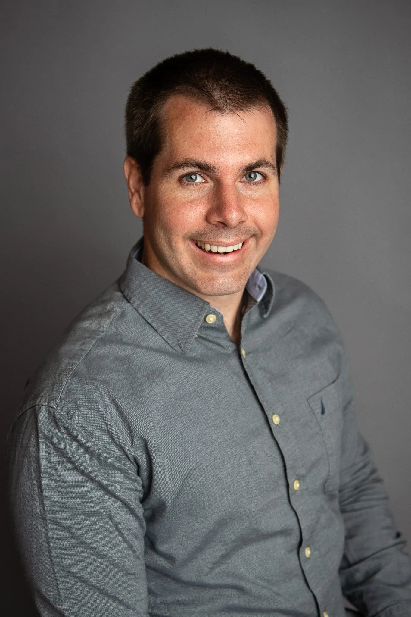 Professional headshot photograph of a man in the photo studio.