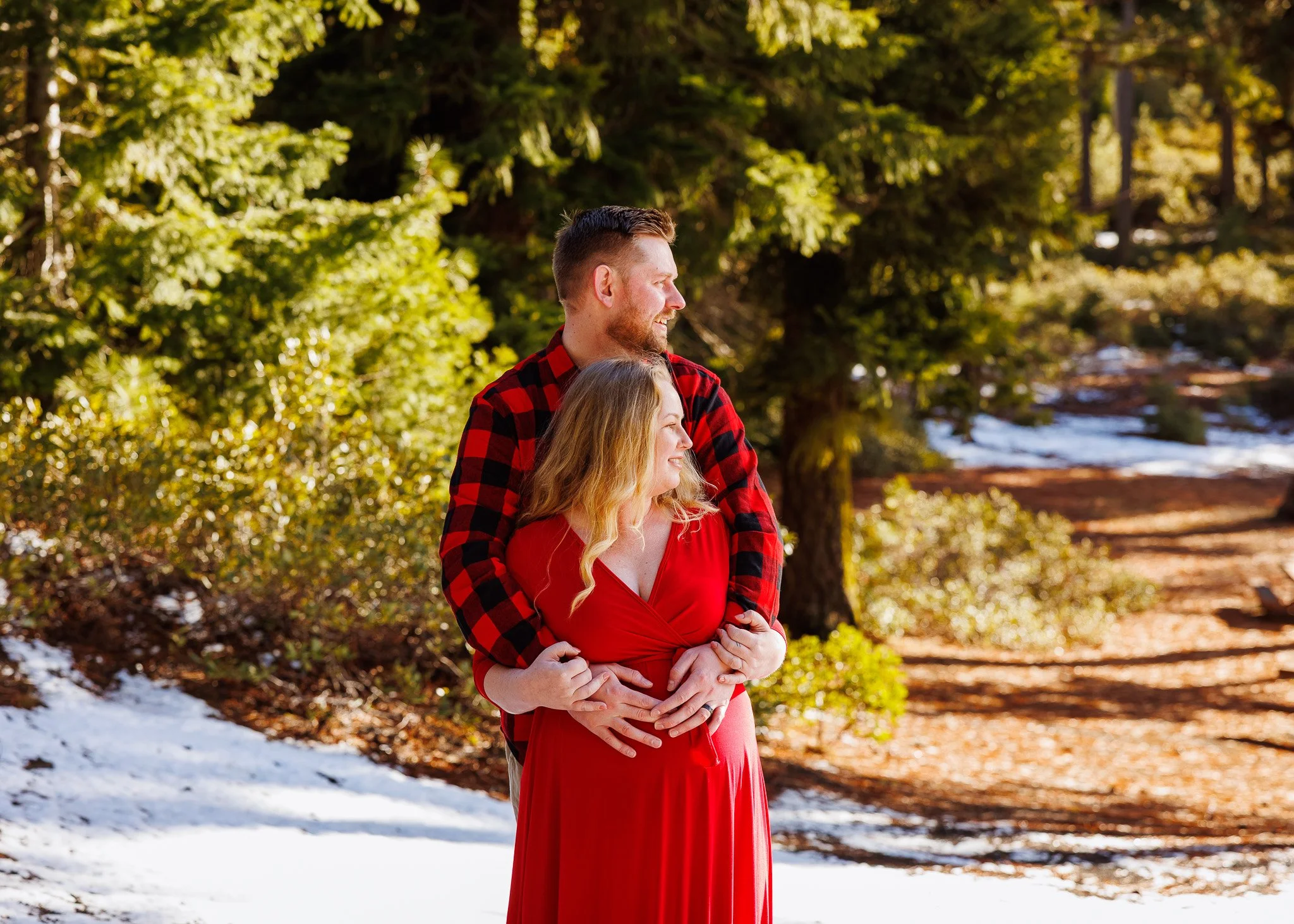 A couple taking outdoor maternity photos with snow on the ground in Central Oregon.