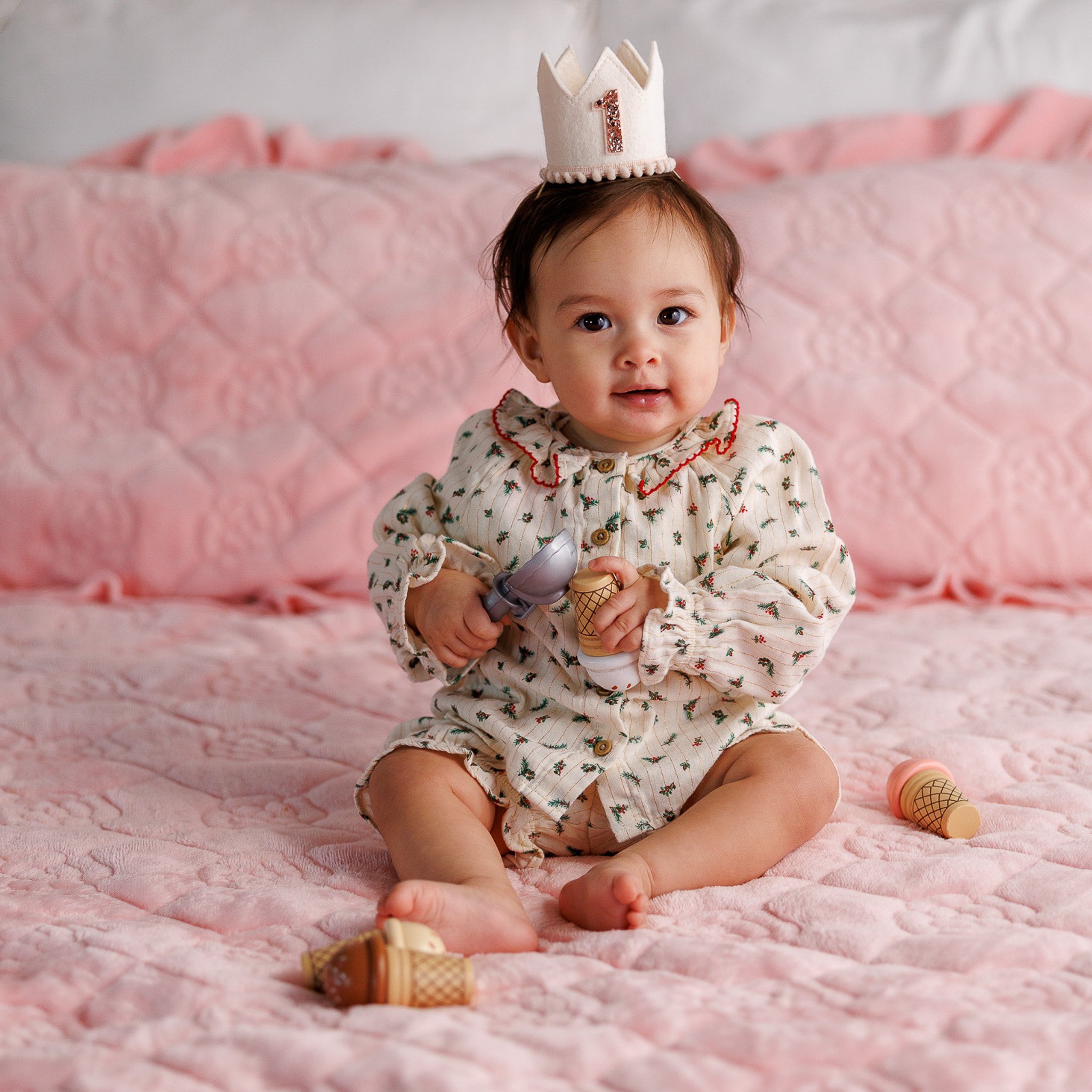 one year old celebrating her first birthday with first birthday hat