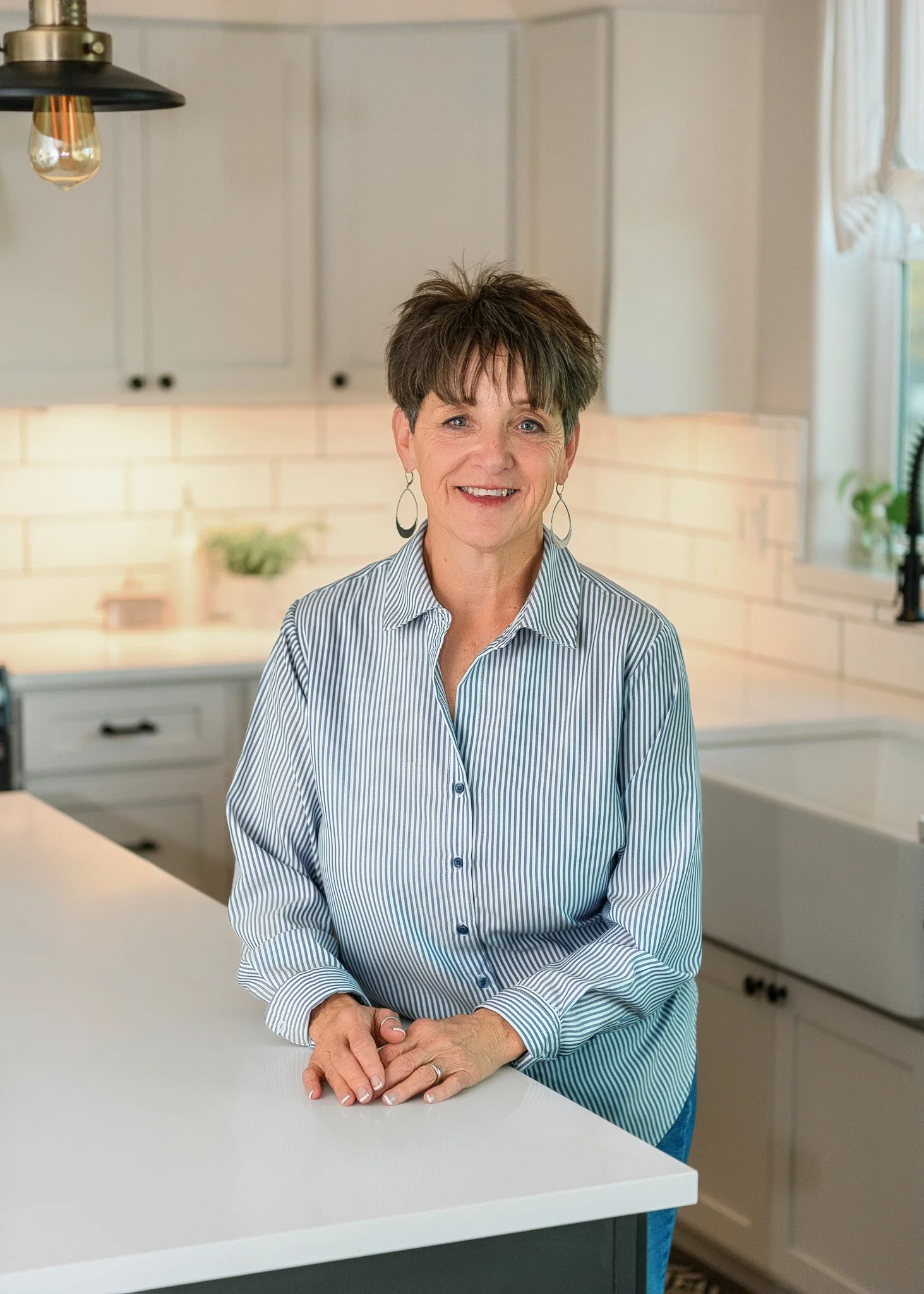 Woman realtor in a white kitchen headshot photograph.