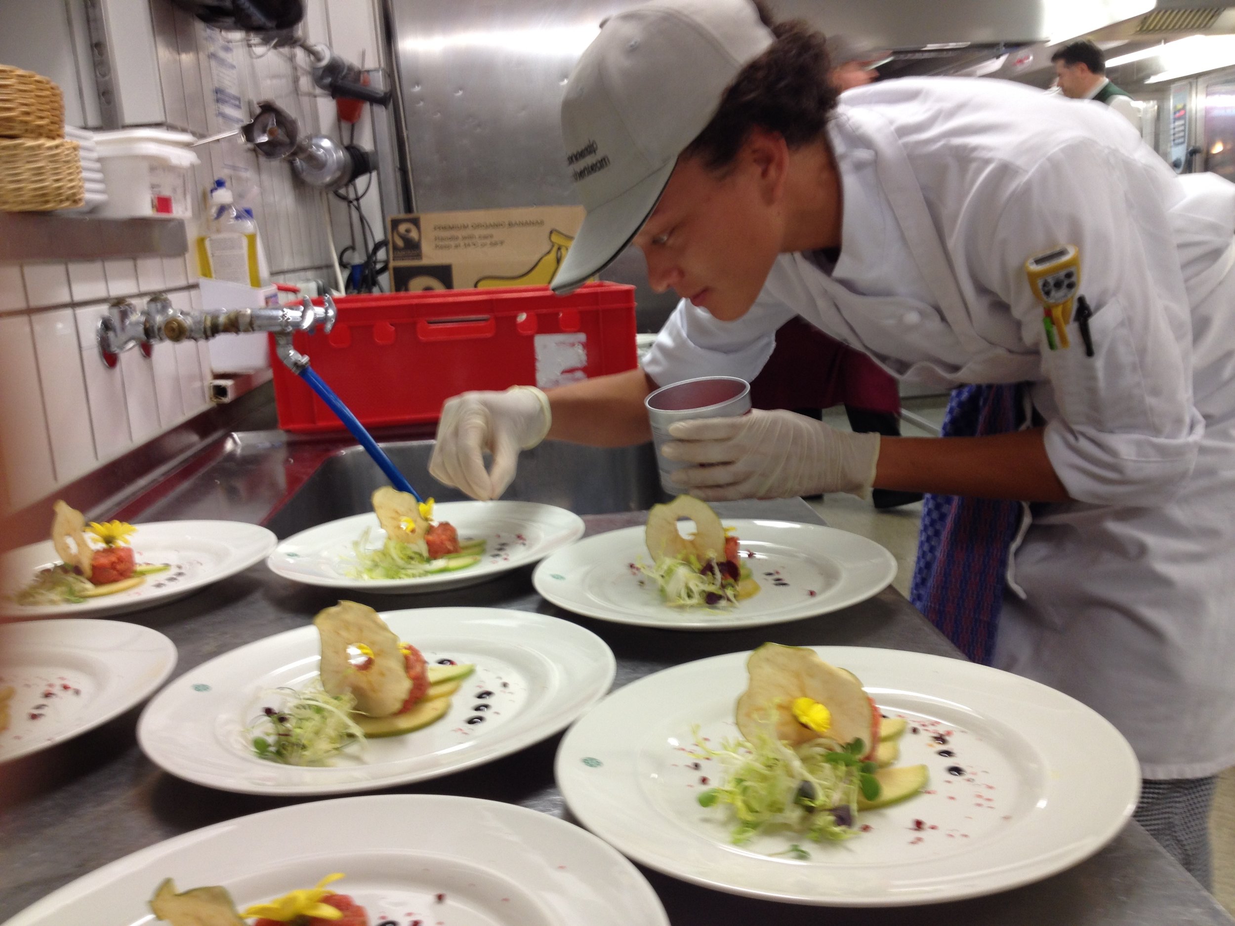 JWU student interns plates gourmet meal.