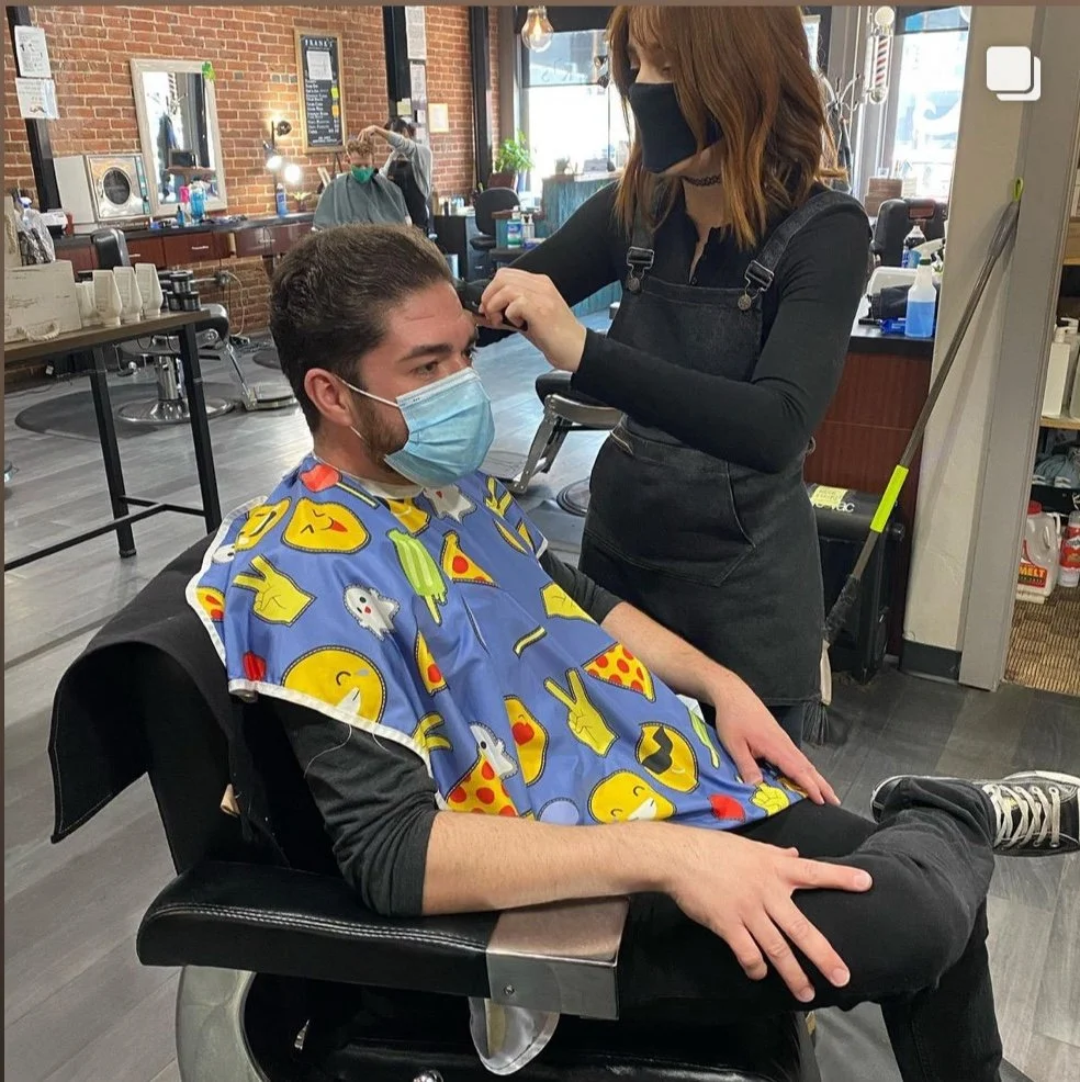 Stylist trimming a client's hair with scissors and comb at Frank's Gentlemen's Salon in Denver