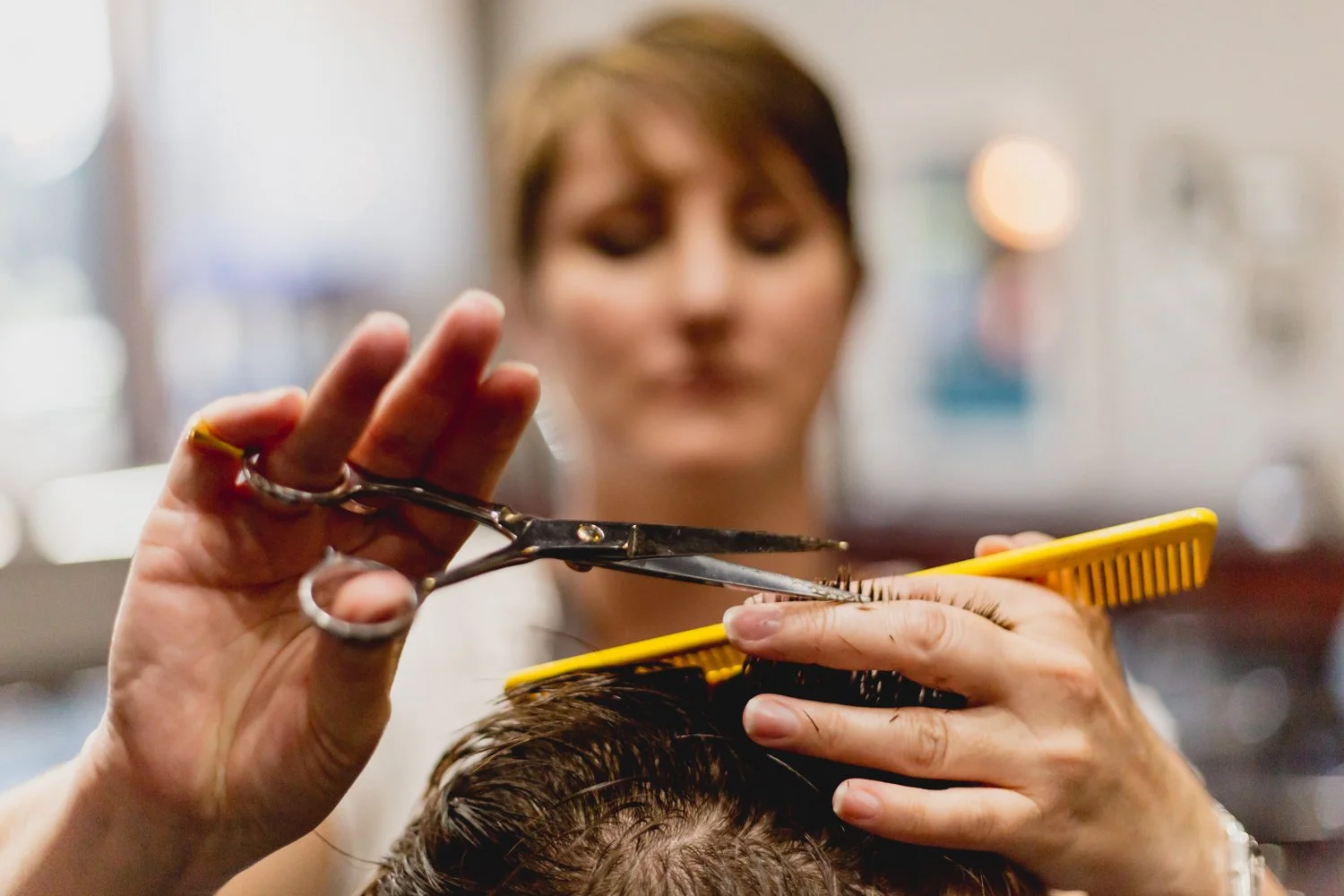 Client in the barber chair getting a men's haircut at Frank's Gentlemen's Salon in Denver