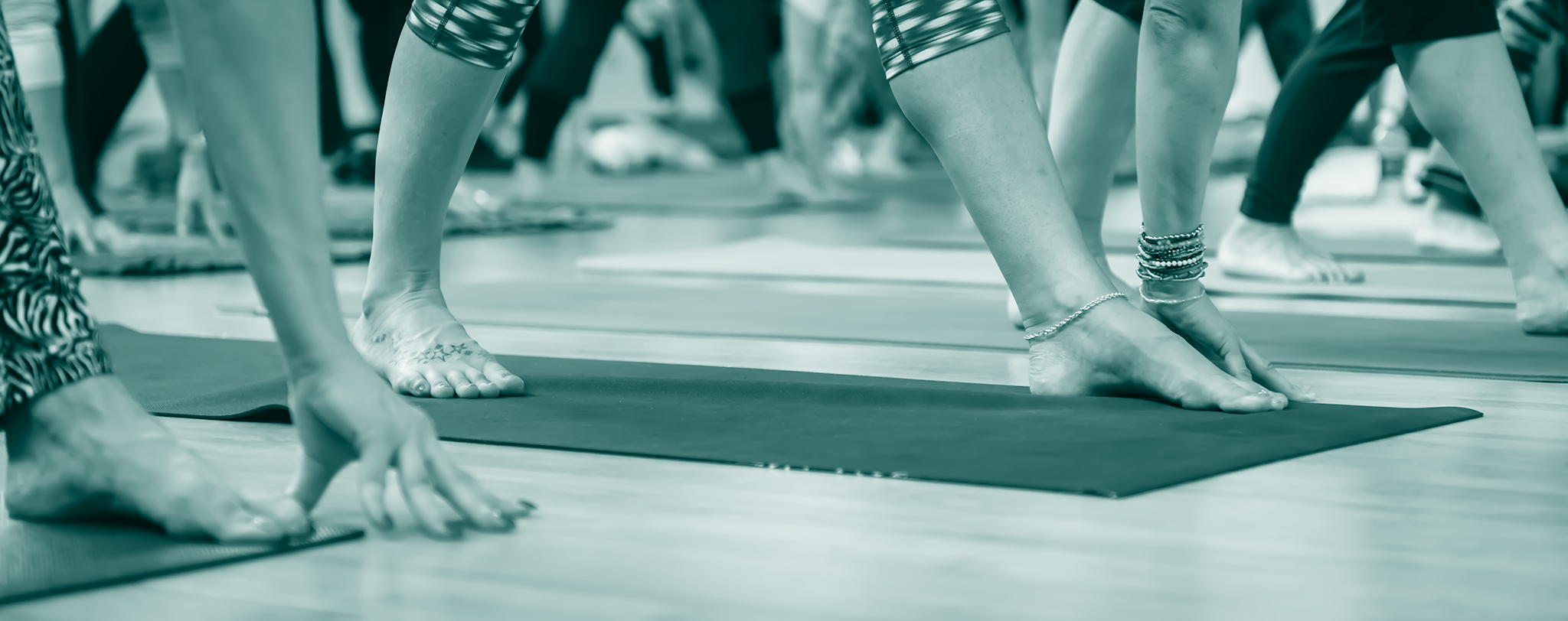 Blue tinted banner picture - showing the feet of people doing yoga